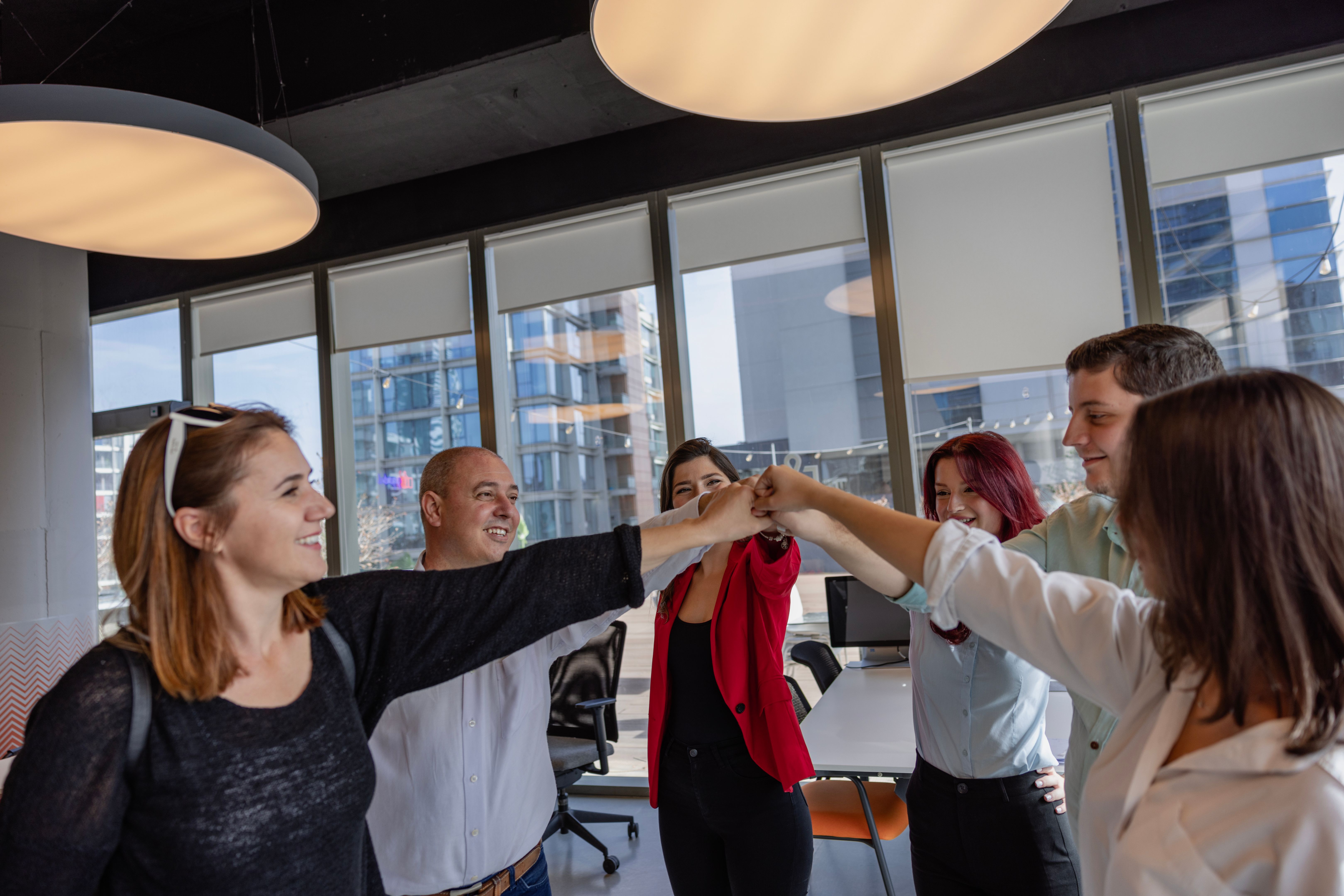A team of colleagues joining their hands together in unity in a creative luxury office A team of colleagues joining their hands together in unity in a creative luxury office