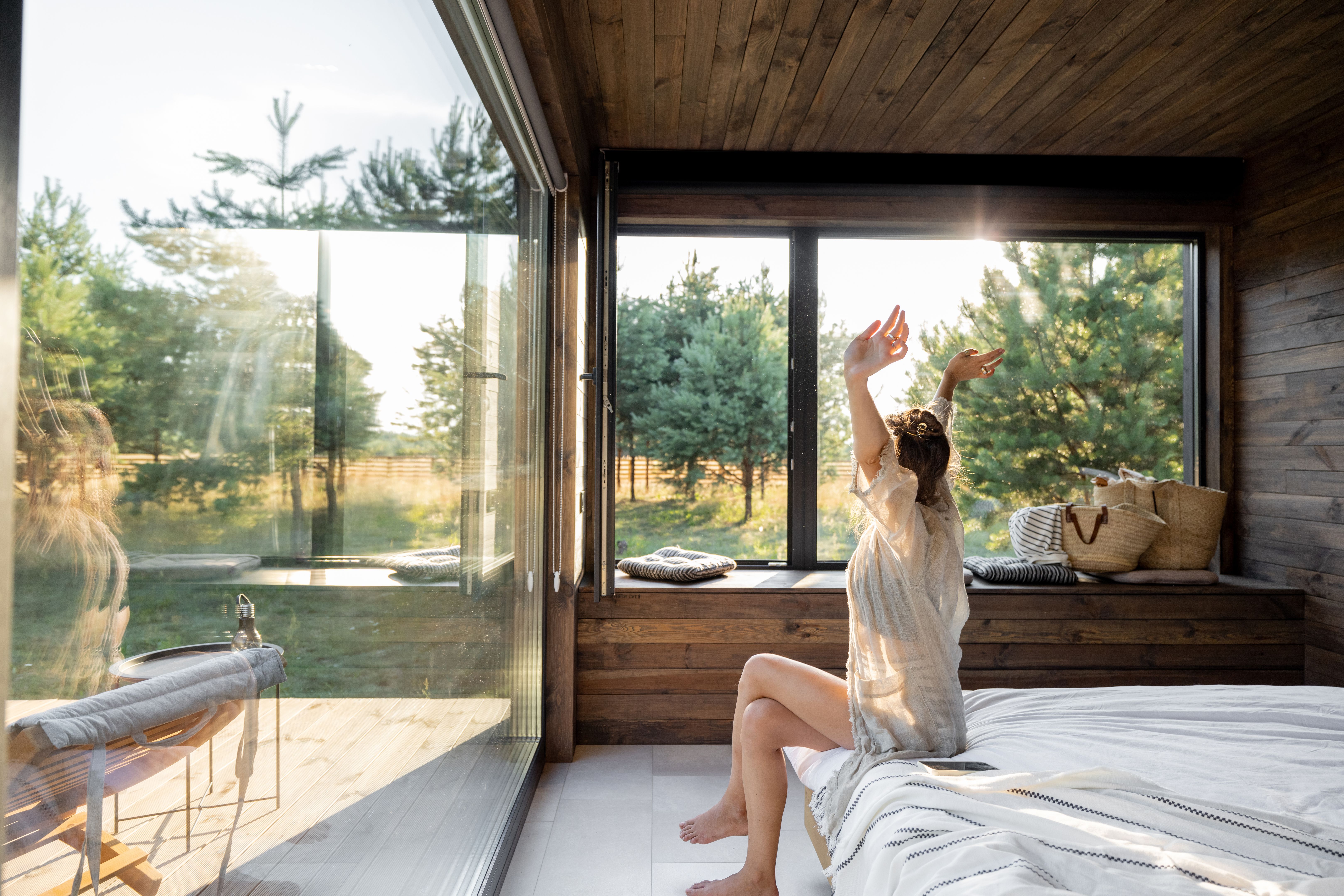 Woman wakes up at country house in nature