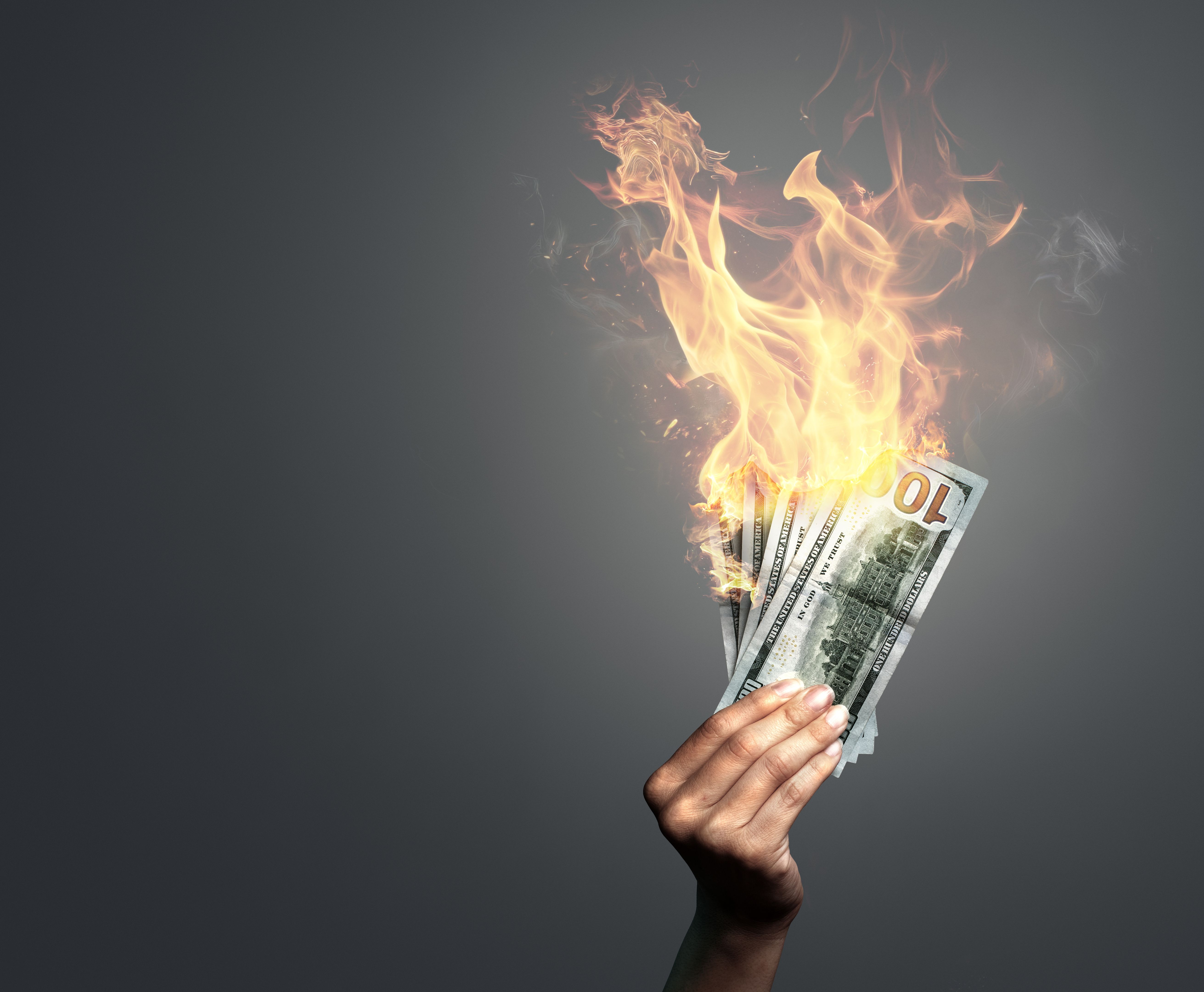 Woman holding burning dollar banknotes