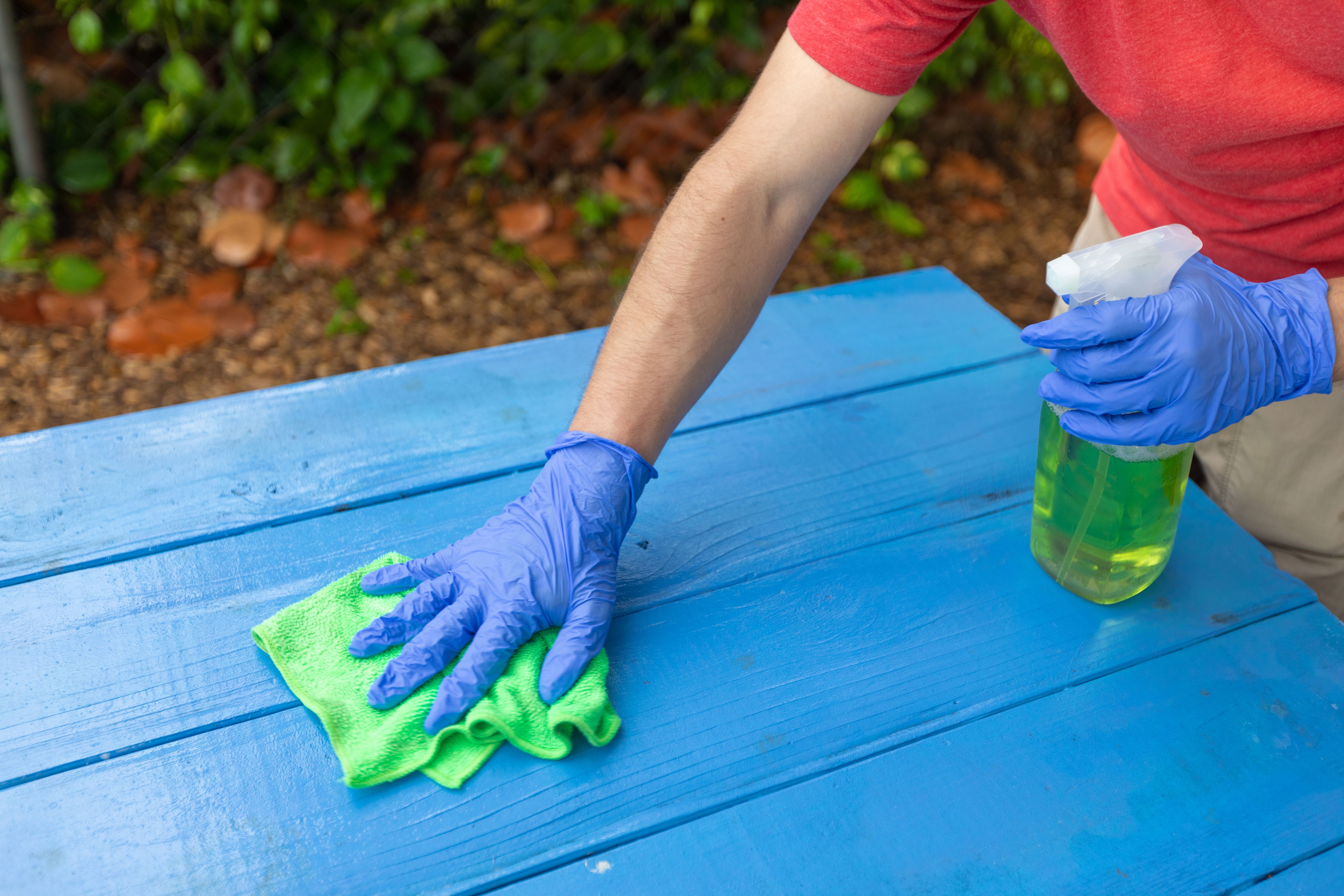 Wiping down a picnic table on a school during covid-19