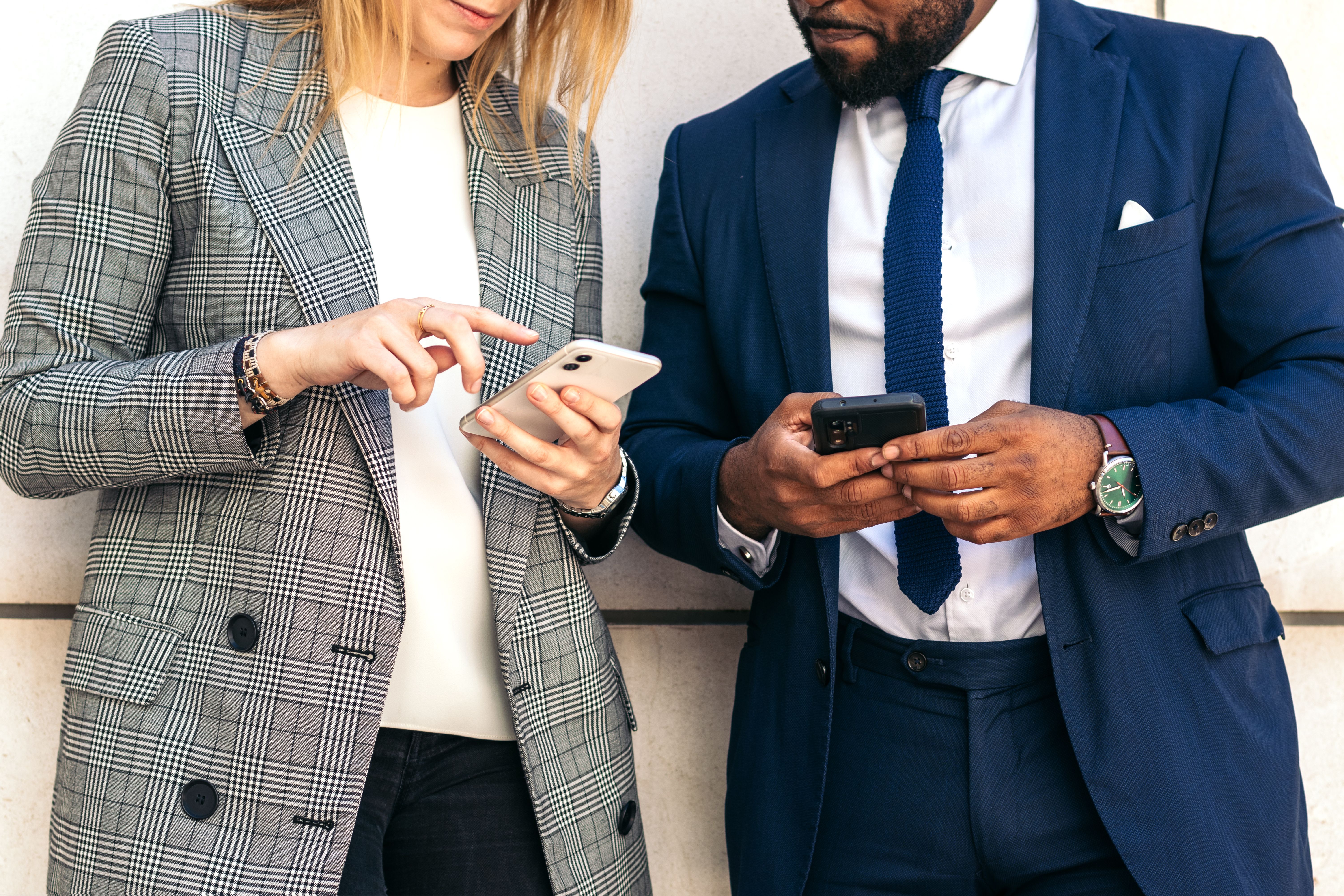 Business people using smartphone outside the office Business people using smartphone outside the office