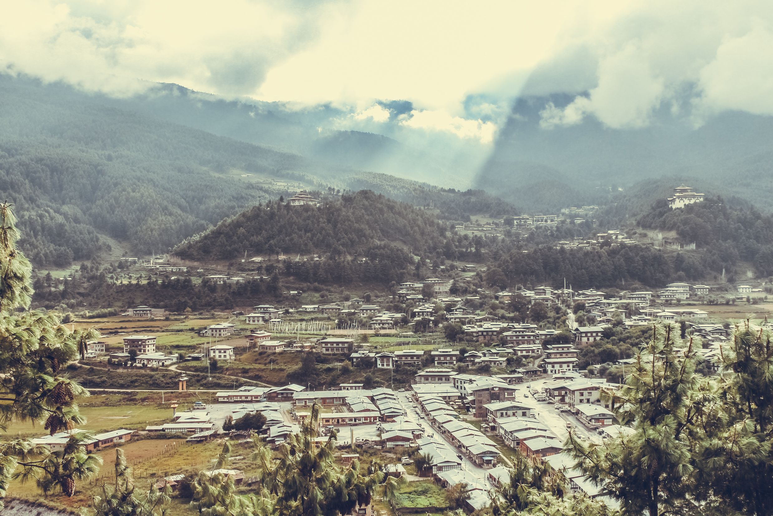 Sunrays leaking from  clouds over peaceful village in Bumthang valley, Bhutan.