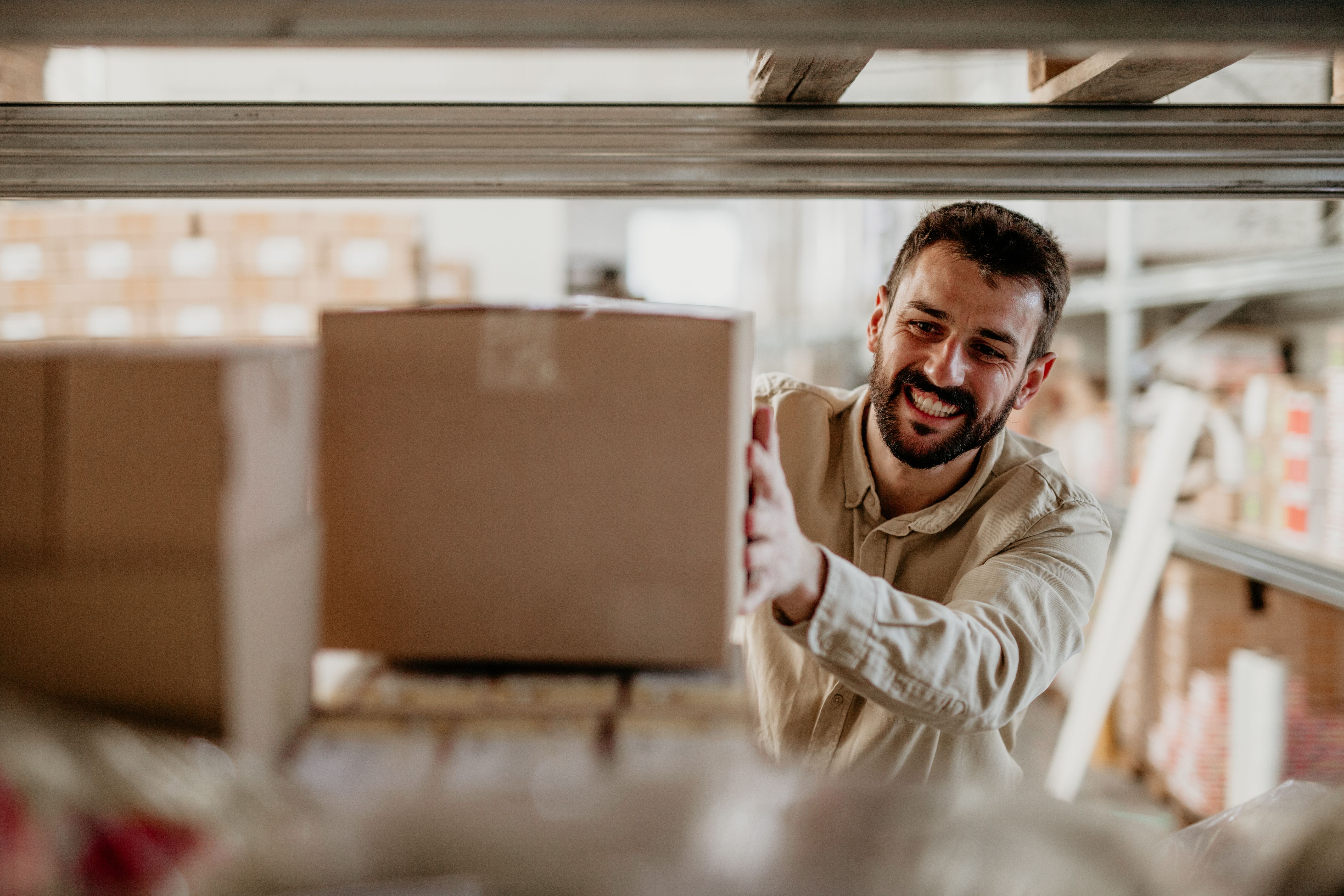 Delivery worker putting a cardboard box on a shelf