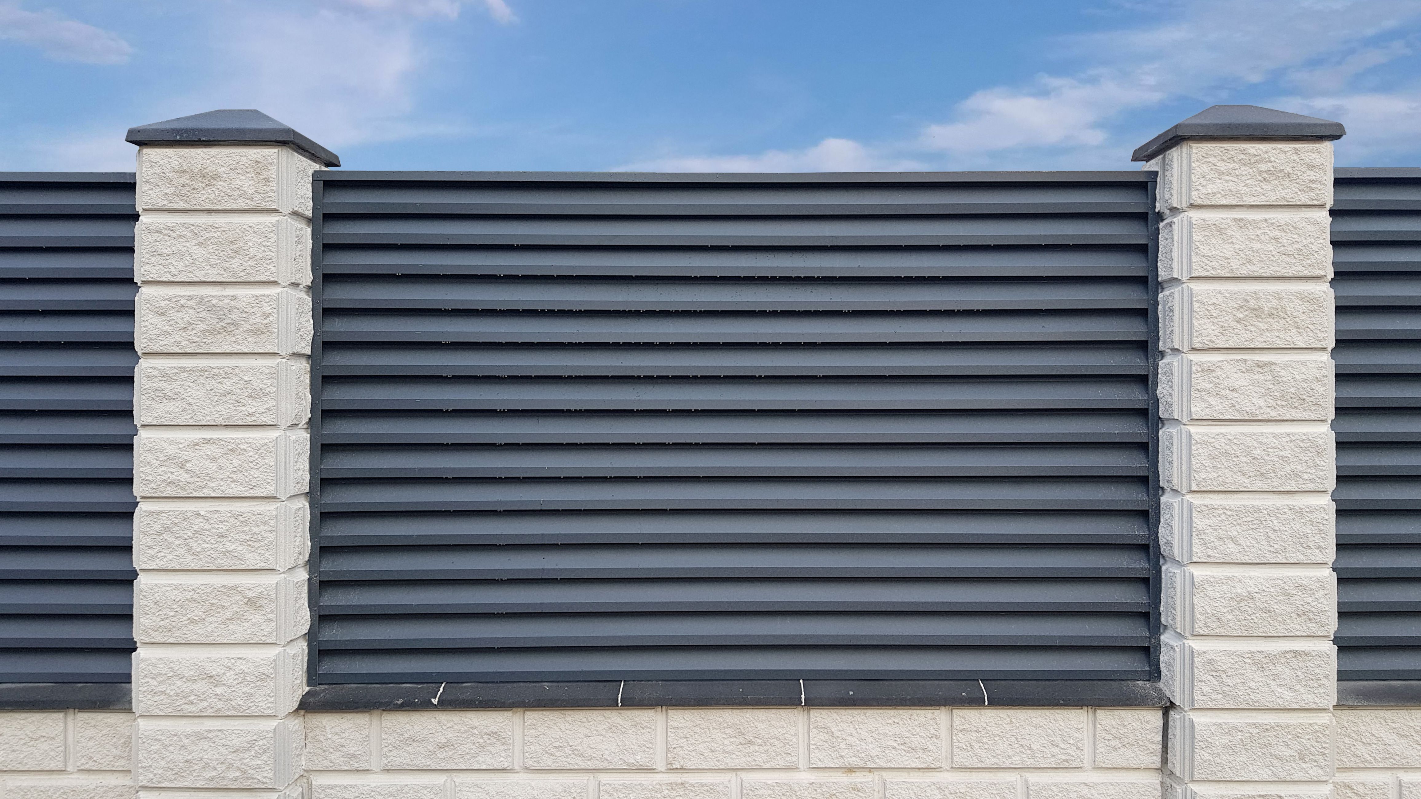 Modern gray metal shutter fence with stone column