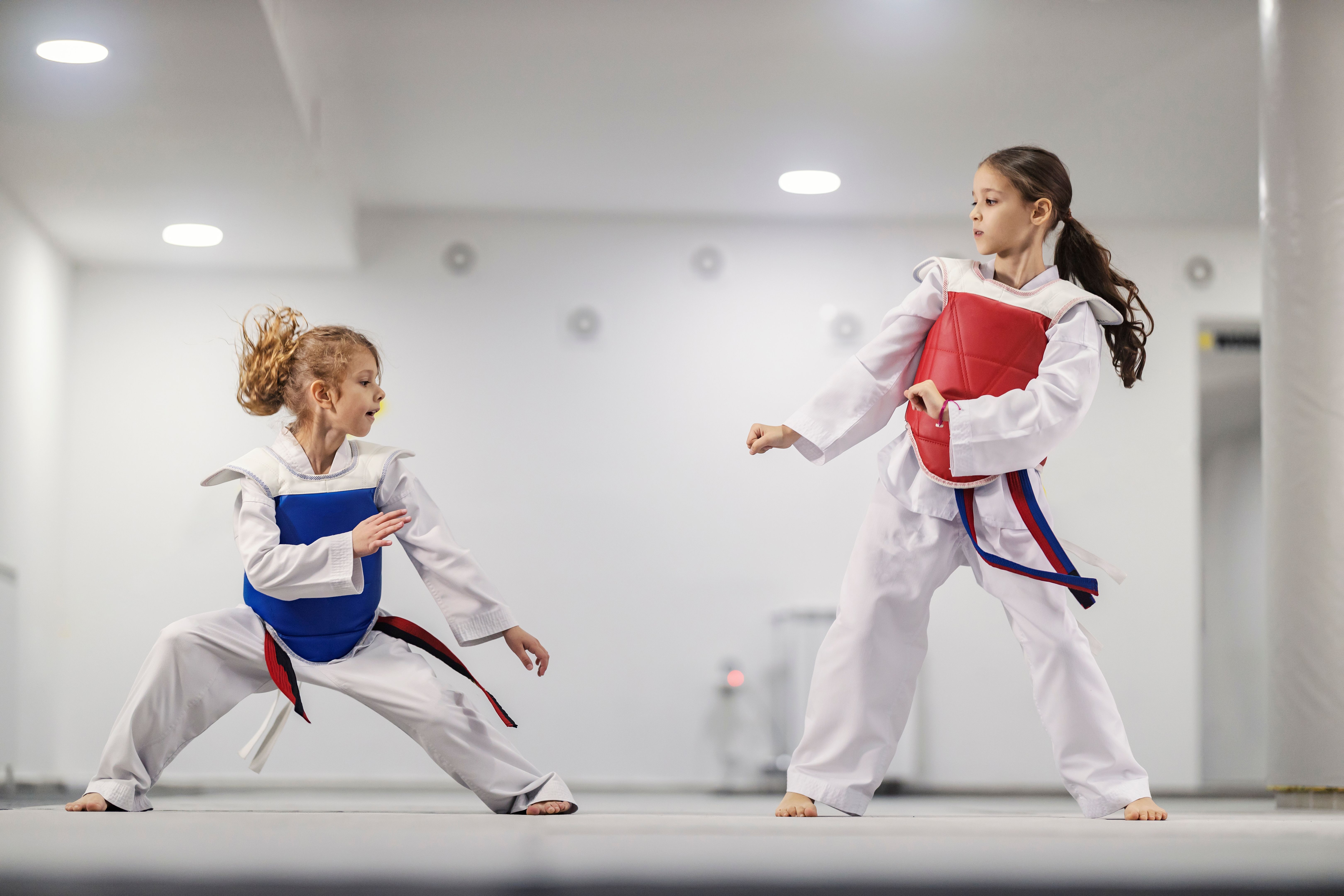 Taekwondo kids in doboks practicing combat in martial art school. Taekwondo kids in doboks practicing combat in martial art school.