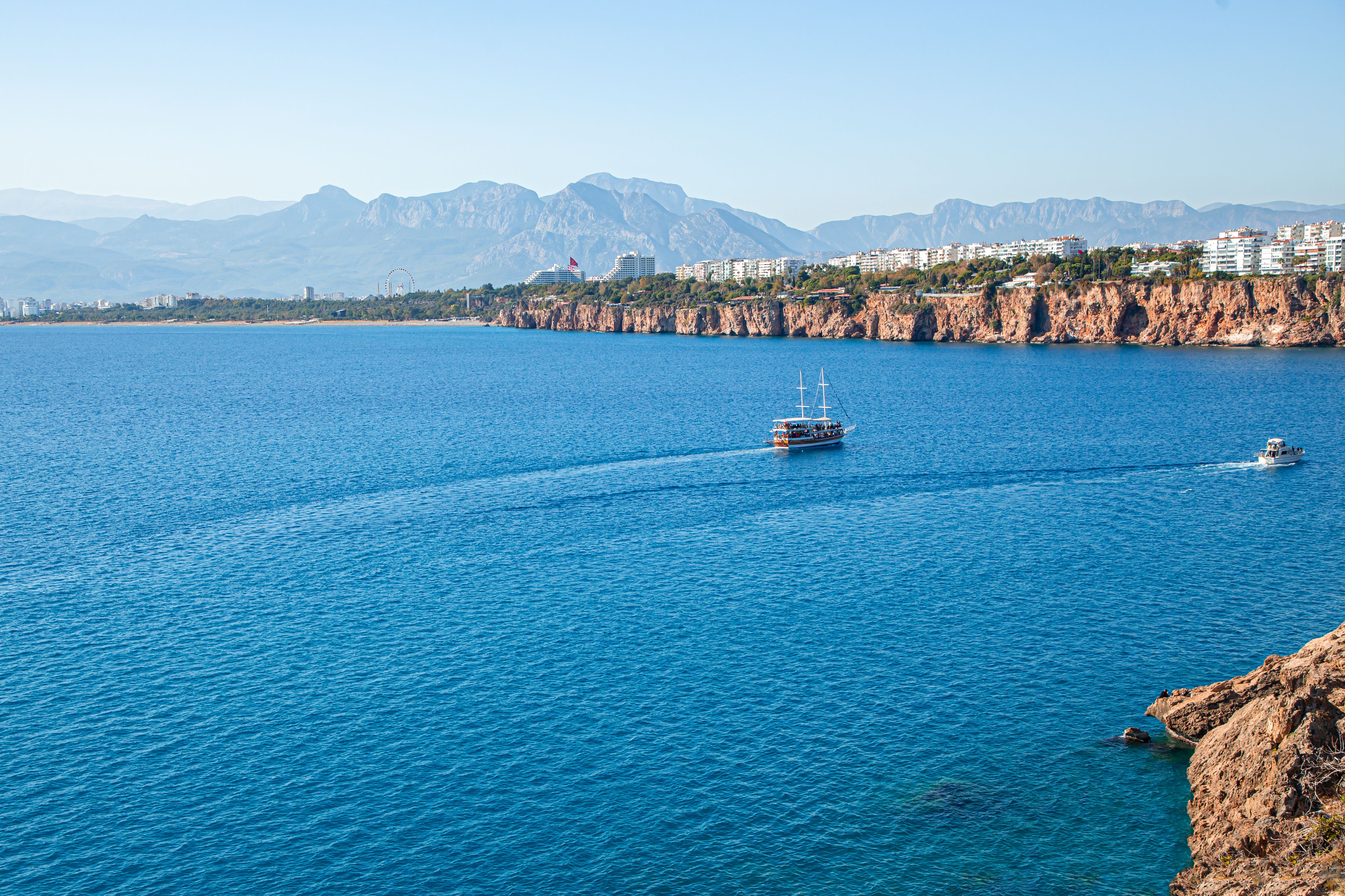 Yacht Tour boat Sailing Along Rugged Rock Shore in Antalya’s Mediterranean Sea