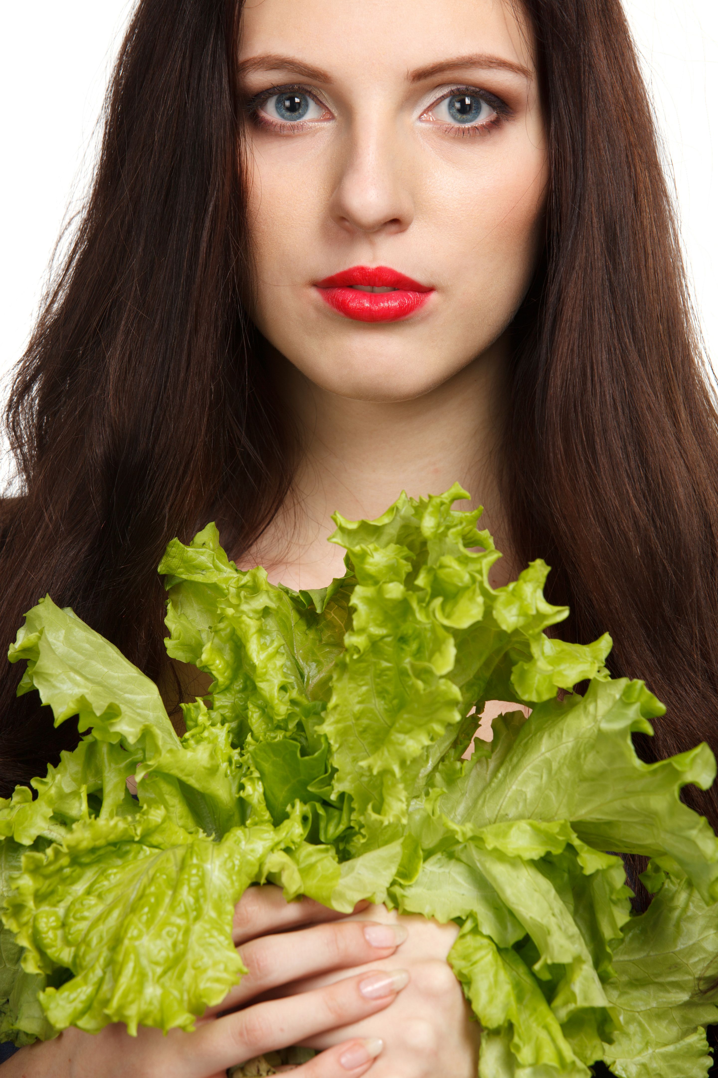 Portrait of young female with green lettuce