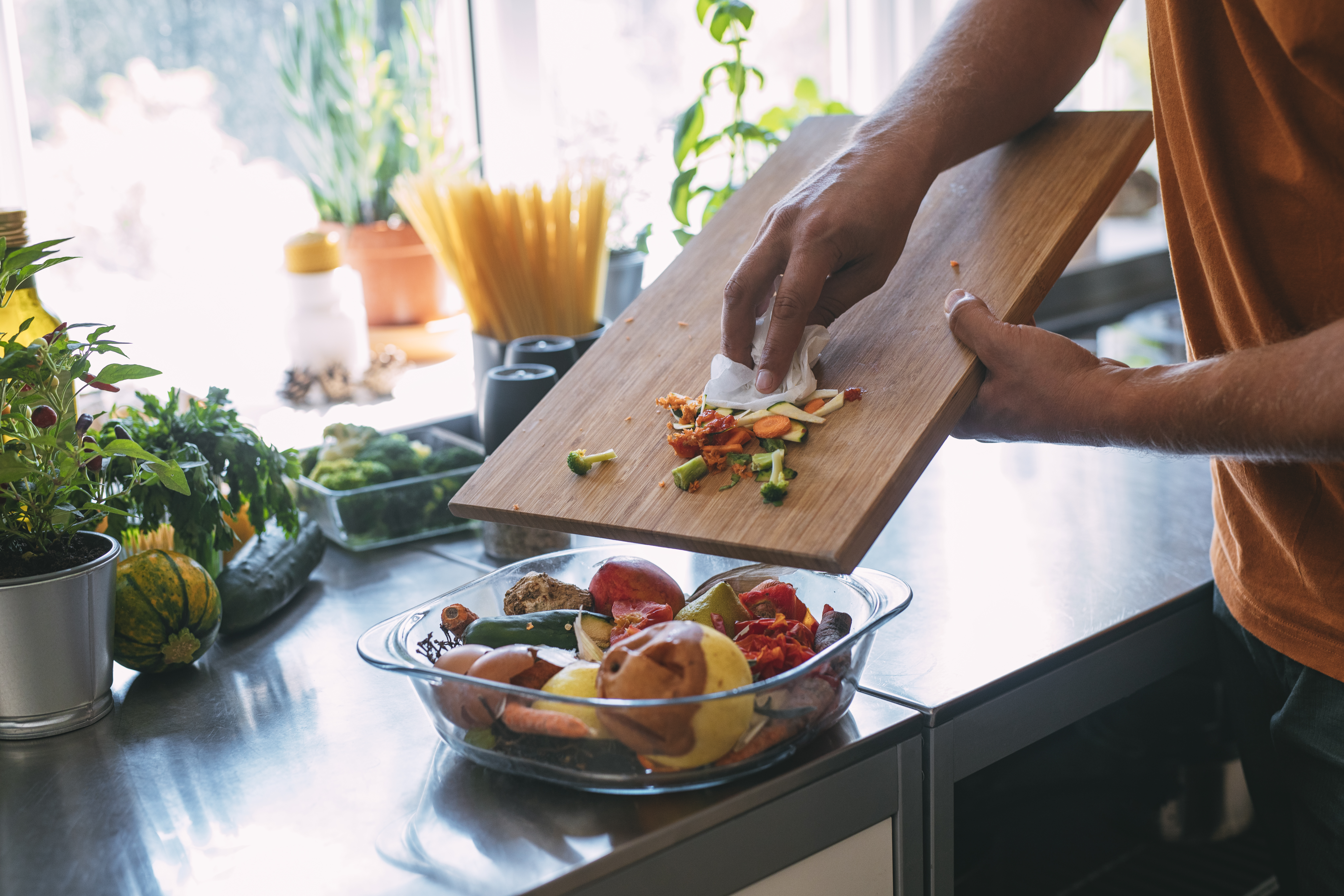 Anonymous Young Caucasian Man Throwing Away Vegetable Remains into a Bowl