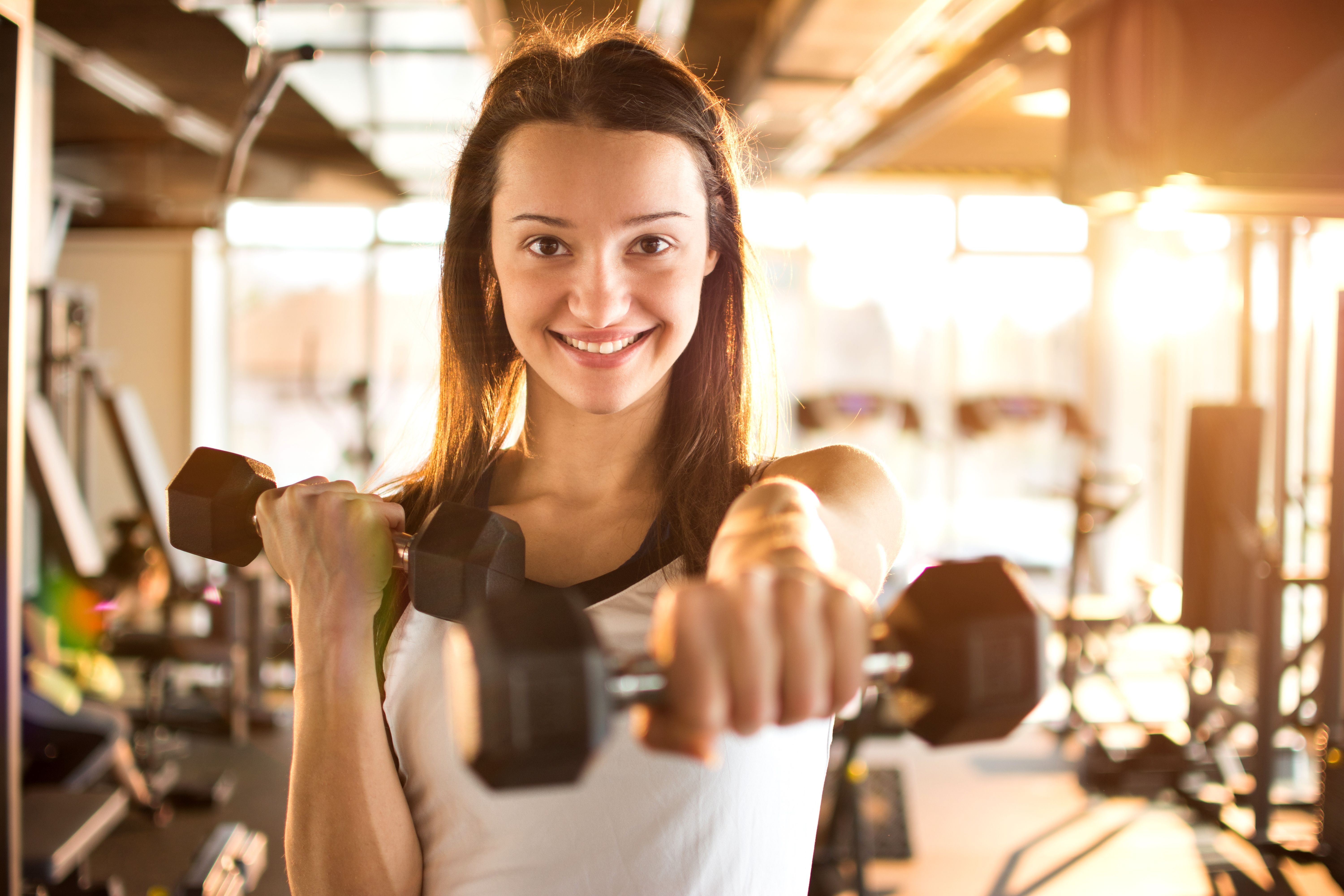 Young woman hang up hand weights
