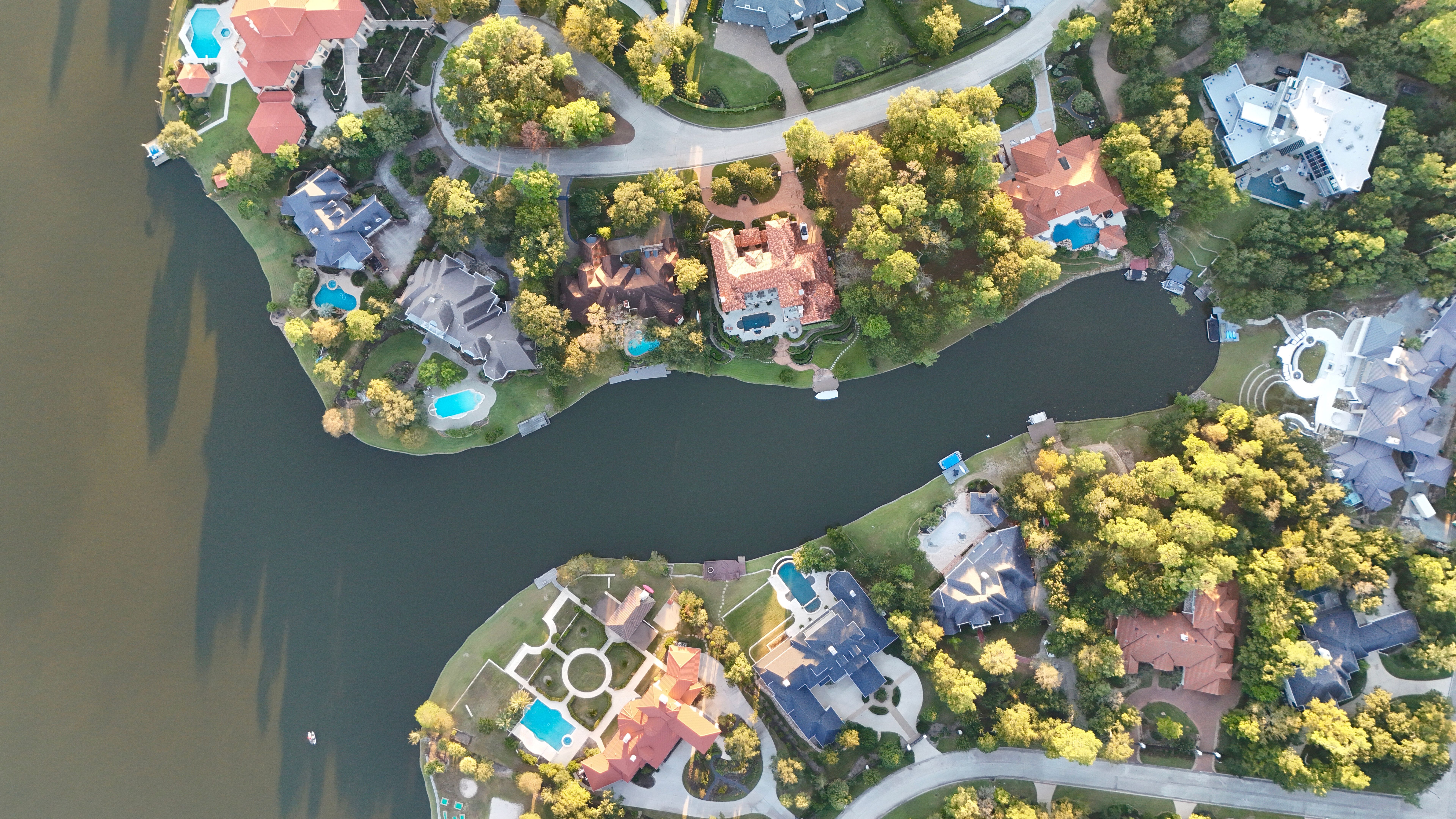 Aerial view of luxurious houses with swimming pool by the lake