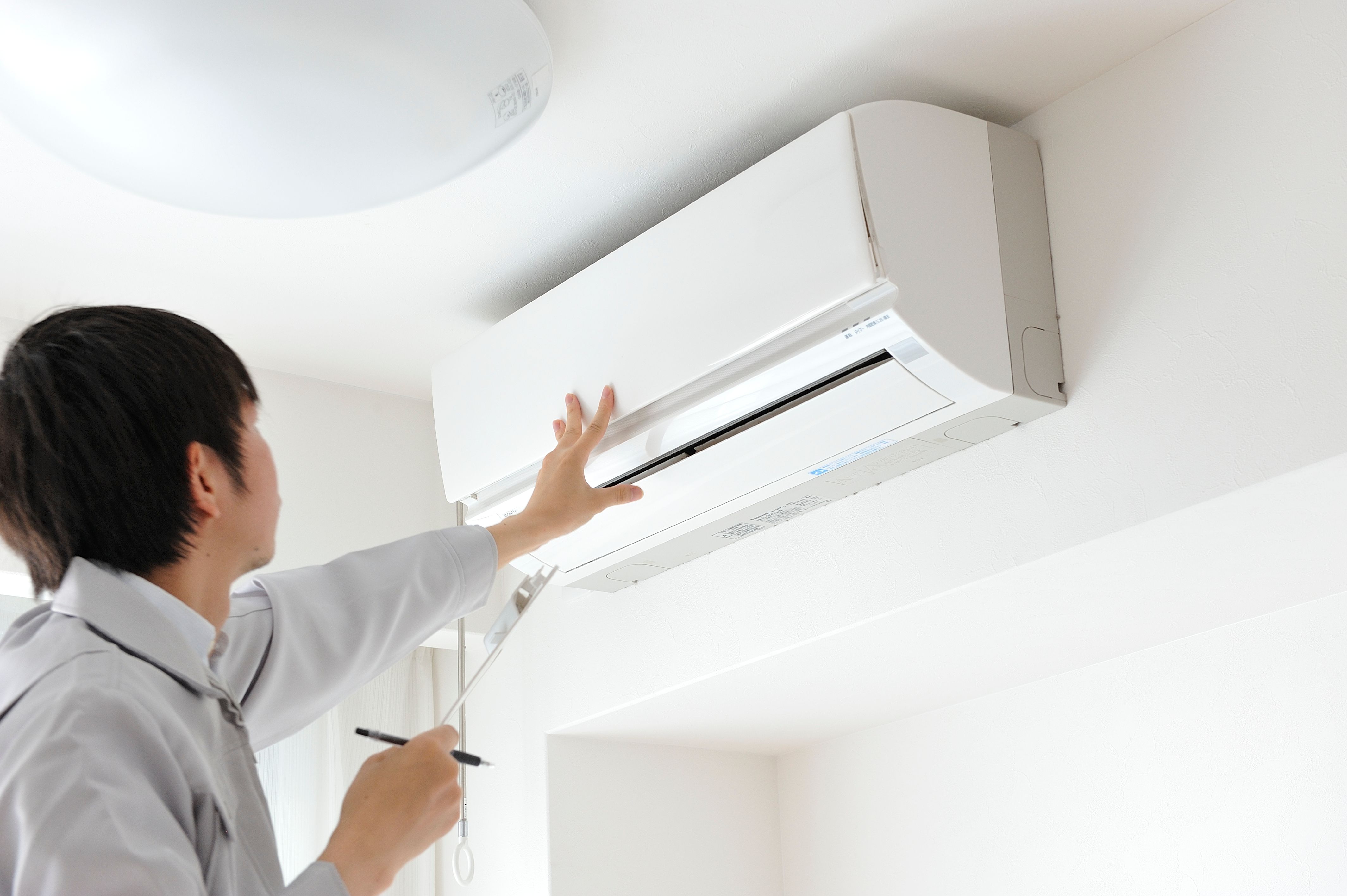 Japanese man dressed for work crews to clean the air conditioner