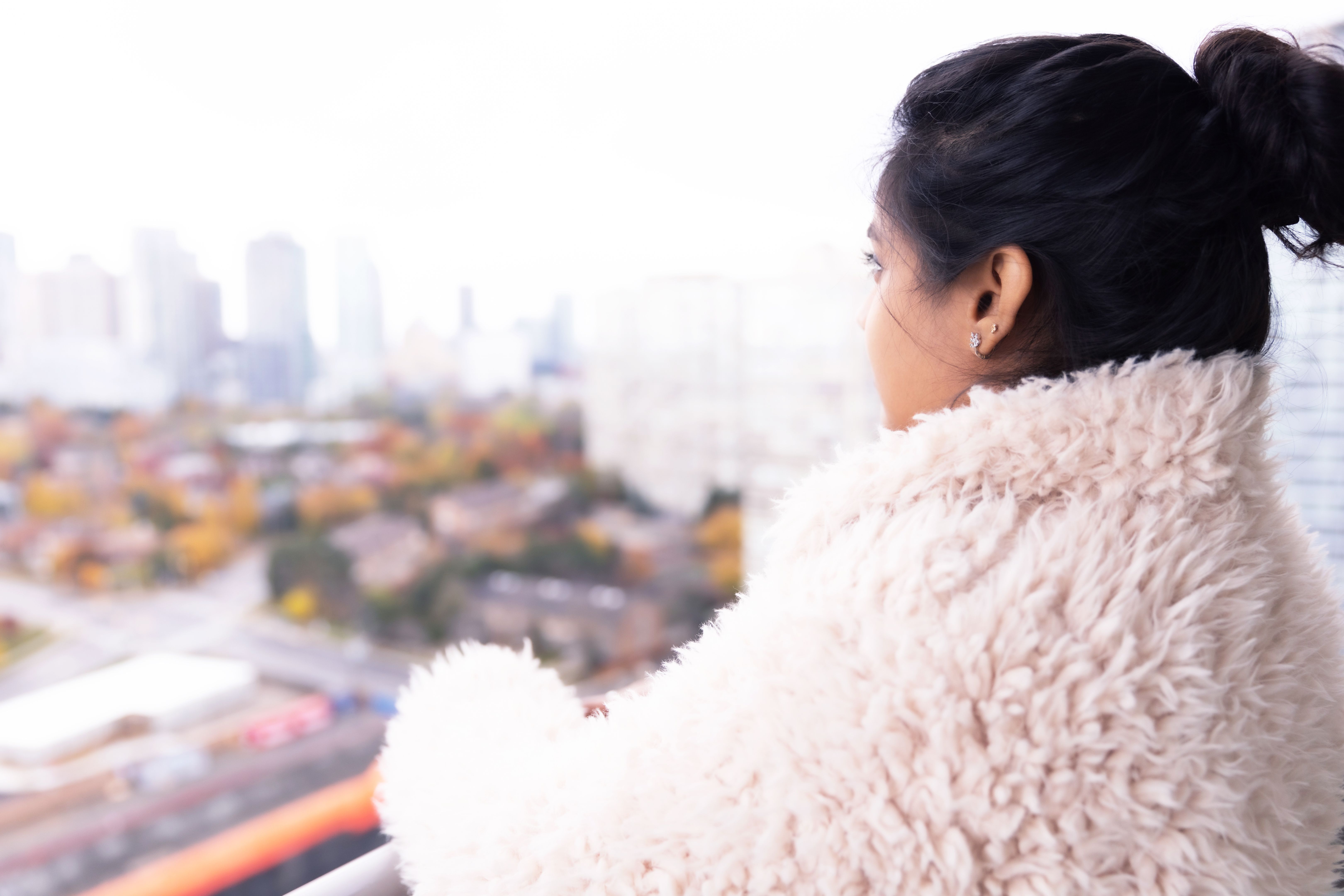 Girl standing at the balcony and admiring views from a highrise