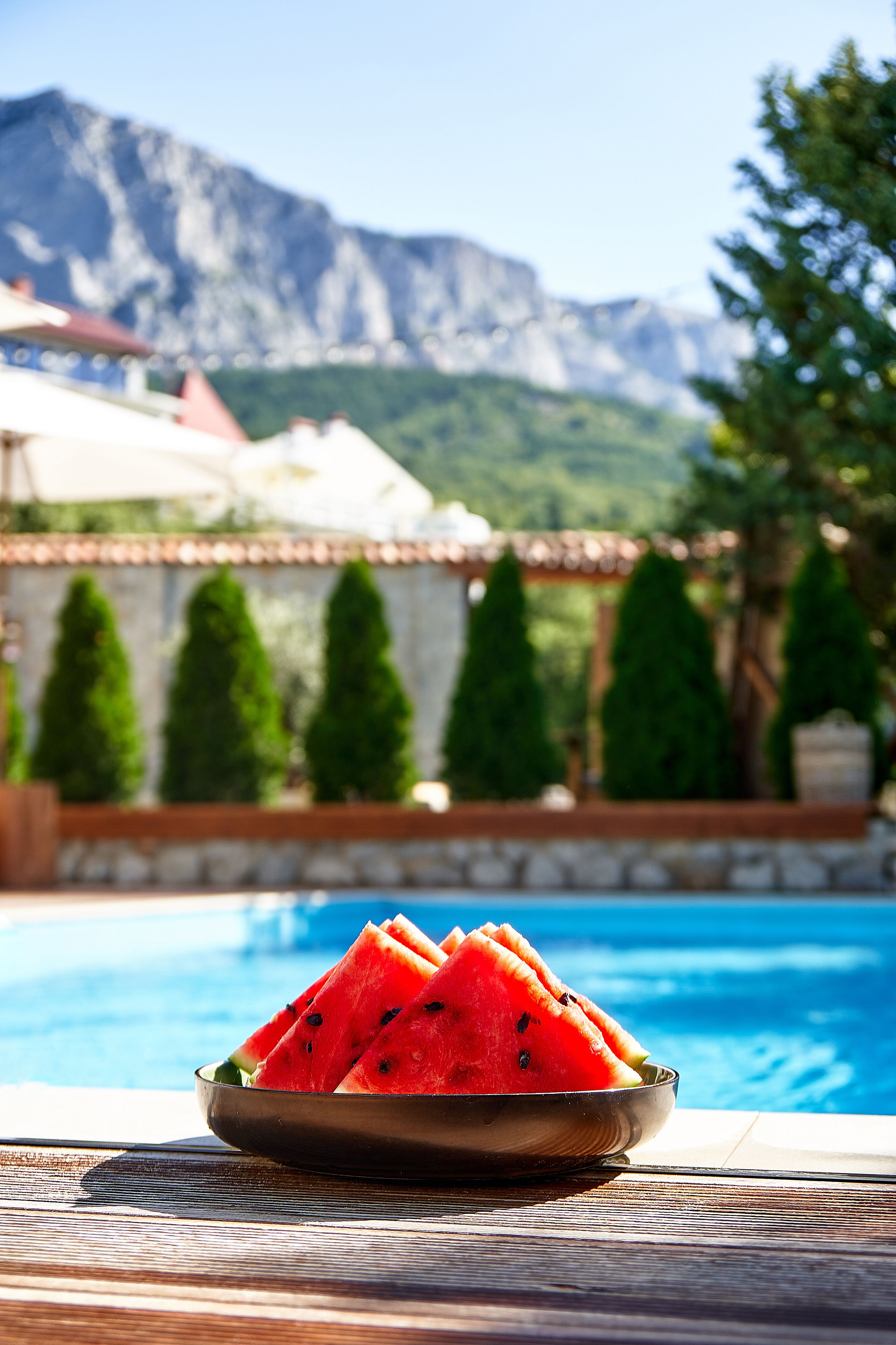 Morning by the pool in the mountains. Sliced watermelon near the pool Morning by the pool in the mountains. Sliced watermelon near the pool
