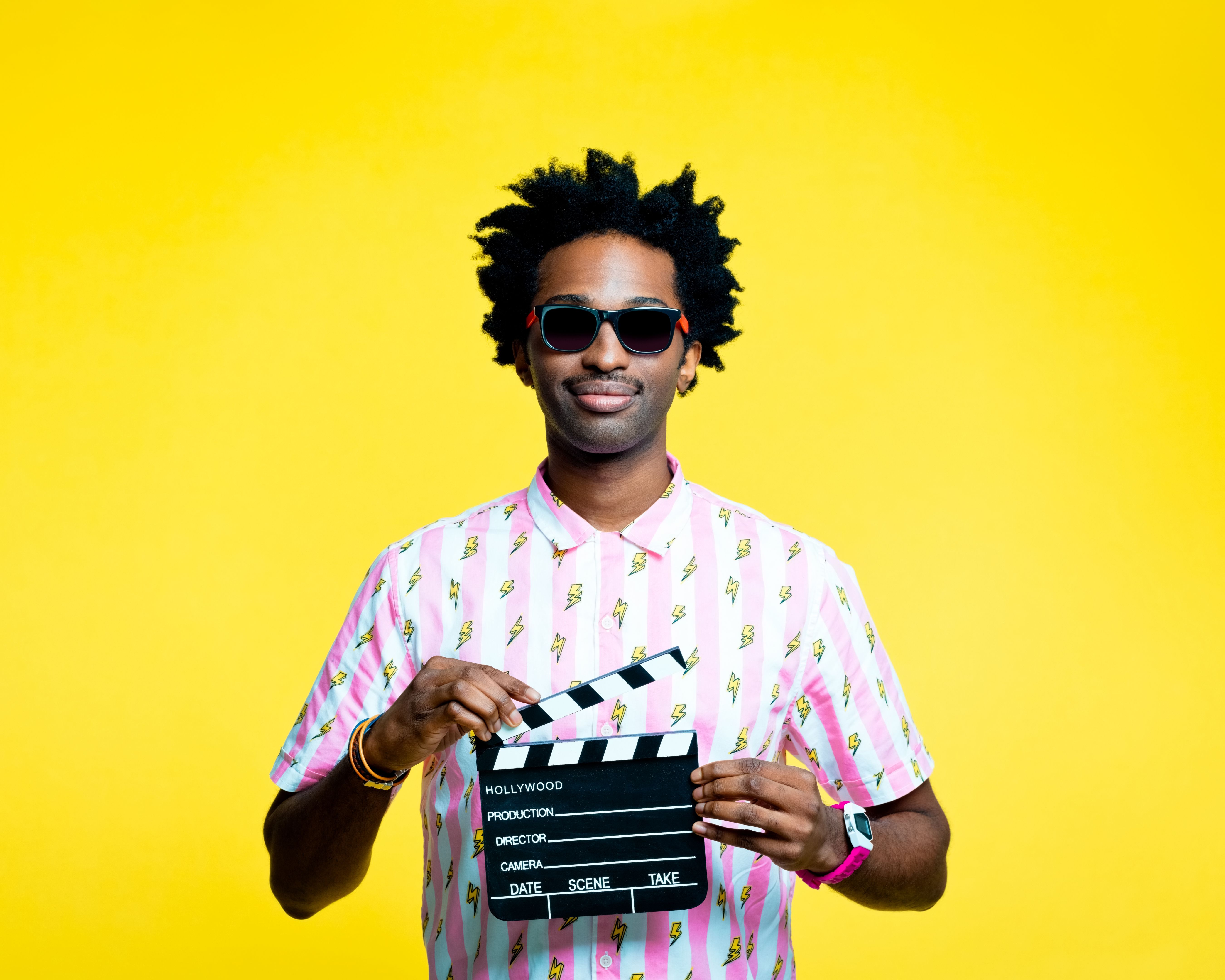 Friendly man holding film clapboard slate, studio portrait Friendly man holding film clapboard slate, studio portrait