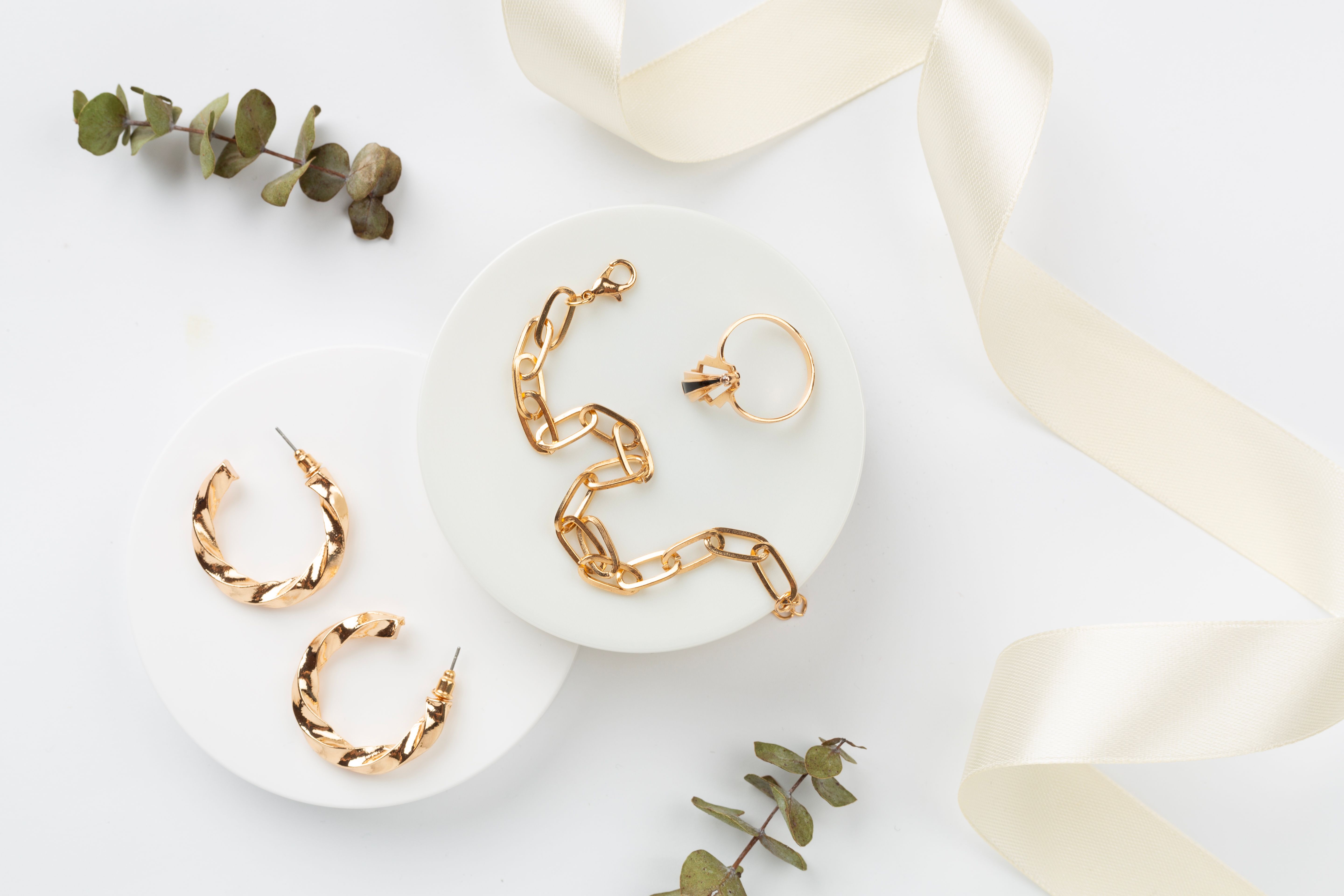 Elegant golden jewelry with decoration on color background, top view