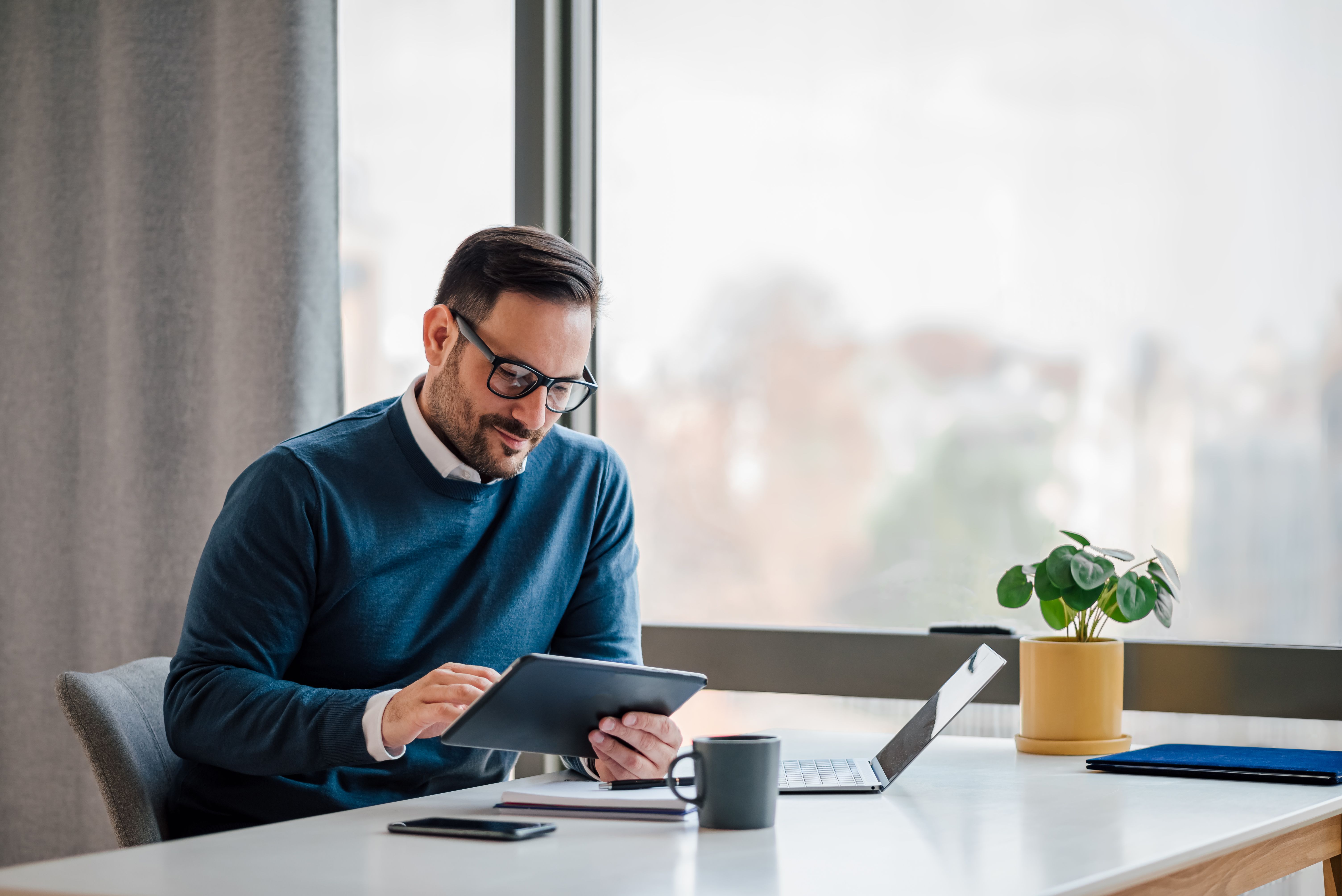 Young businessman using digital tablet while working in business office.