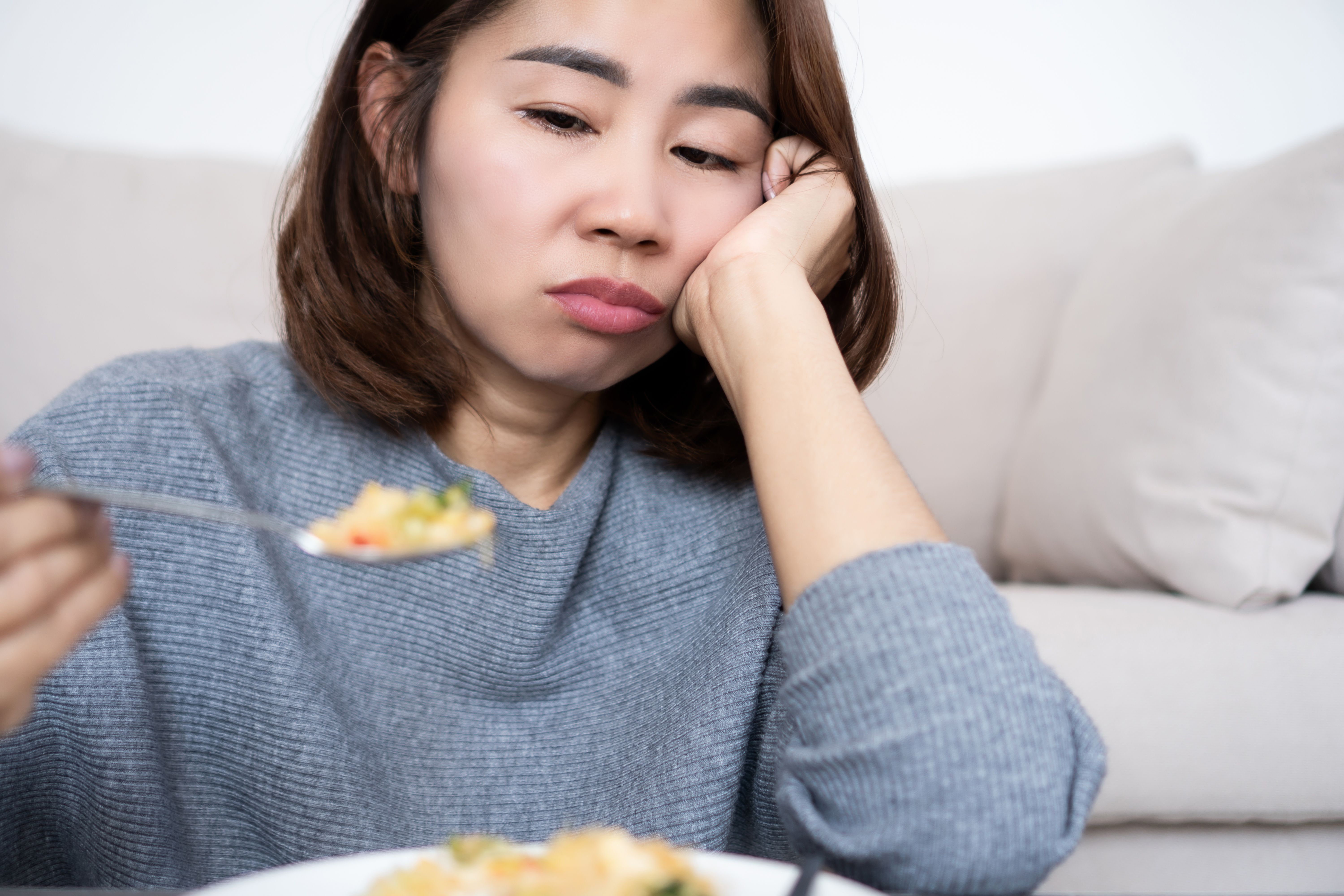 Asian woman loss of appetite and food tasteless, boredom with eating and weight loss Asian woman loss of appetite and food tasteless, boredom with eating and weight loss