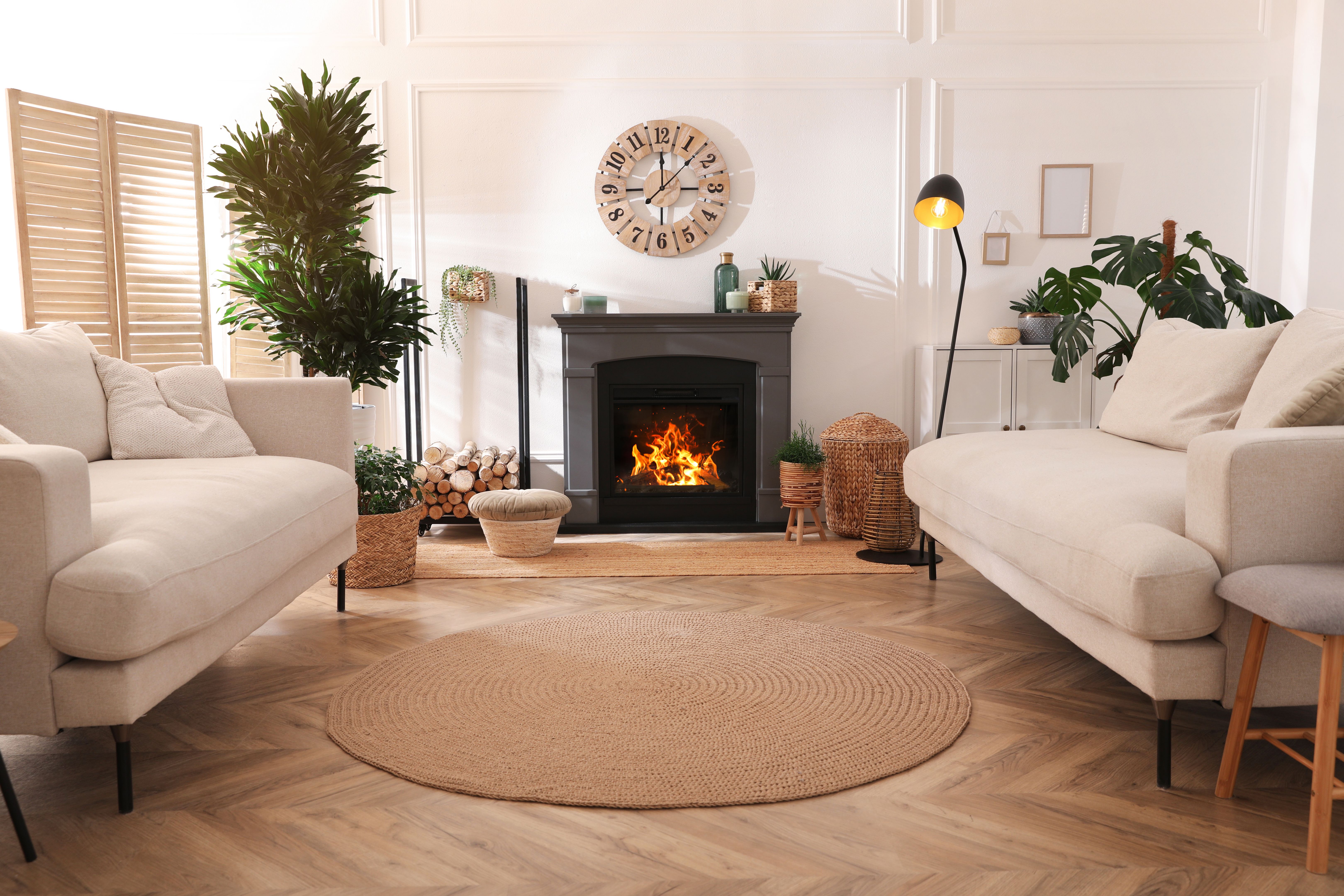 Stylish living room interior with electric fireplace, comfortable sofas and beautiful decor elements