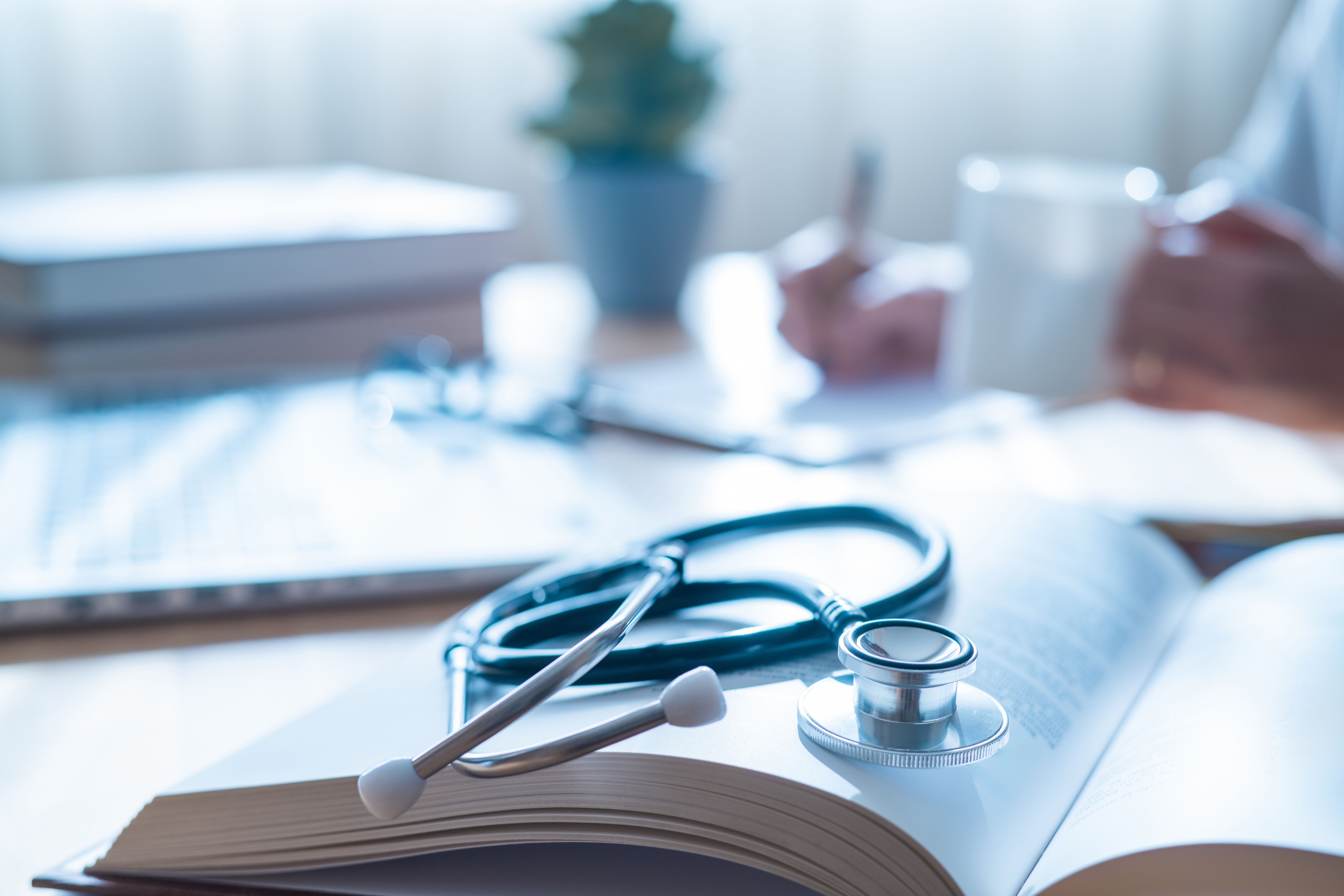 Nonprofit compliance concept with stethoscope on open book, symbolizing audits, training, and technology tools for regulatory compliance.