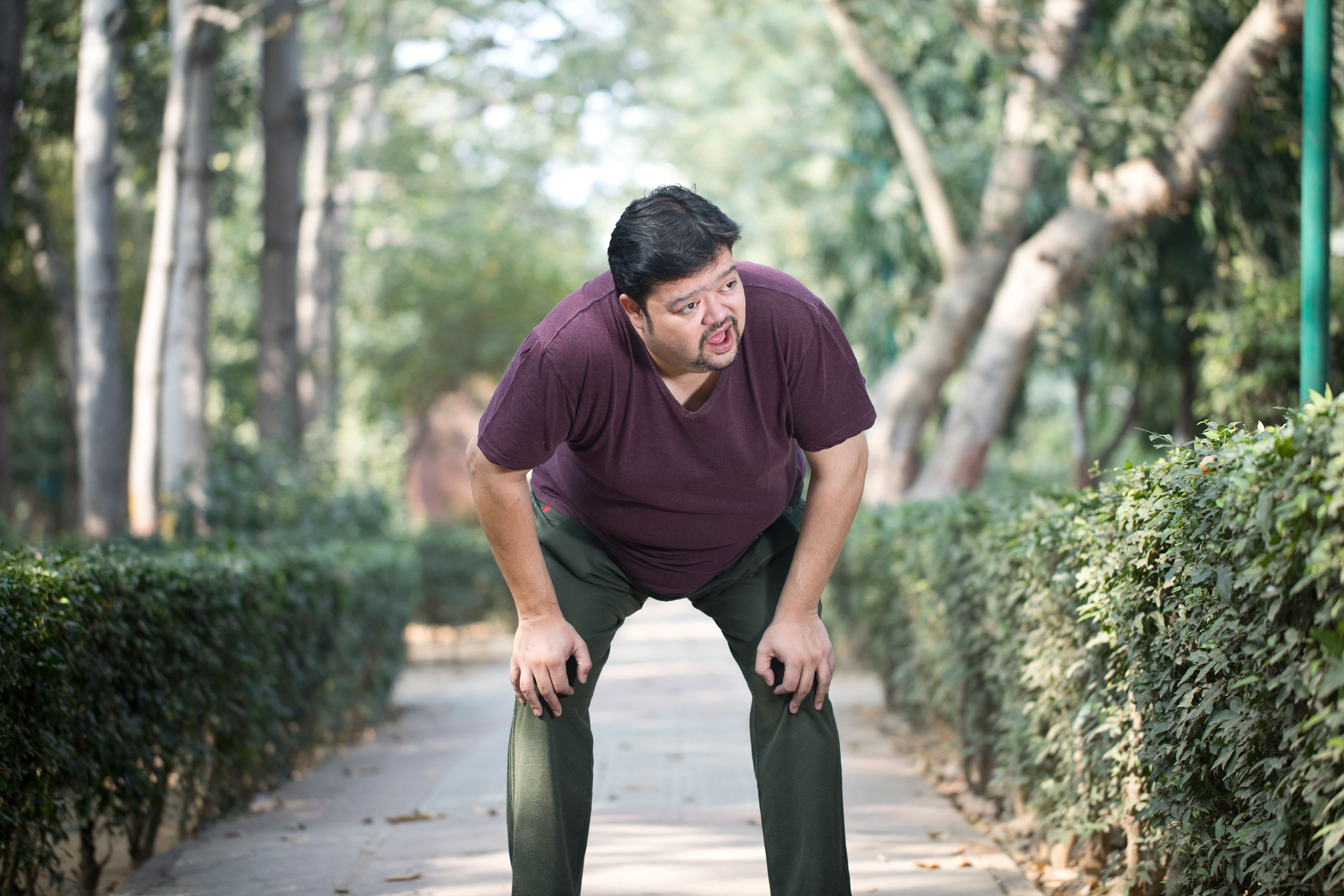 Man is taking a break after running out of breath at park