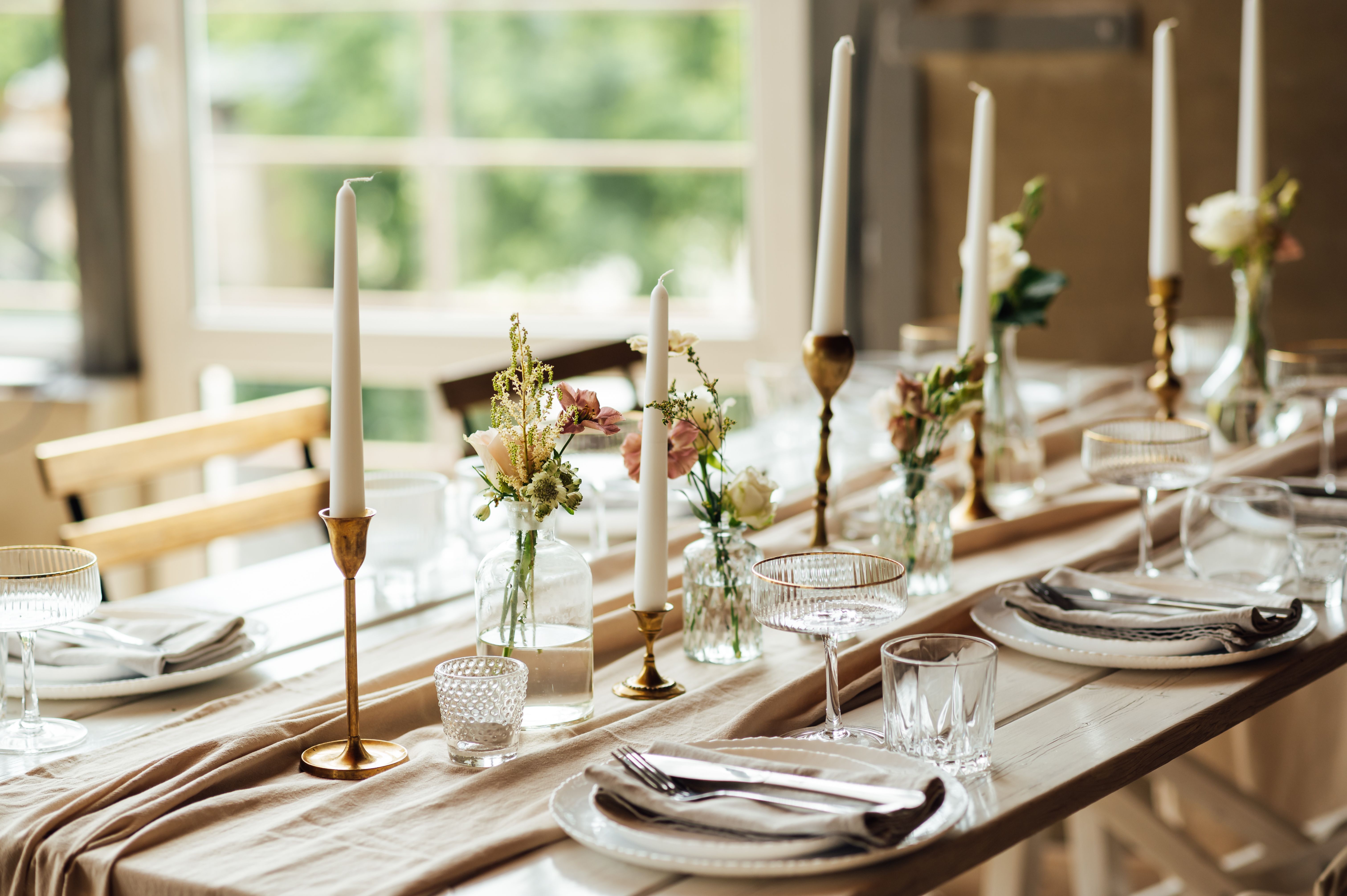 Elegant neutral coloured wedding table scape with flowers and candles