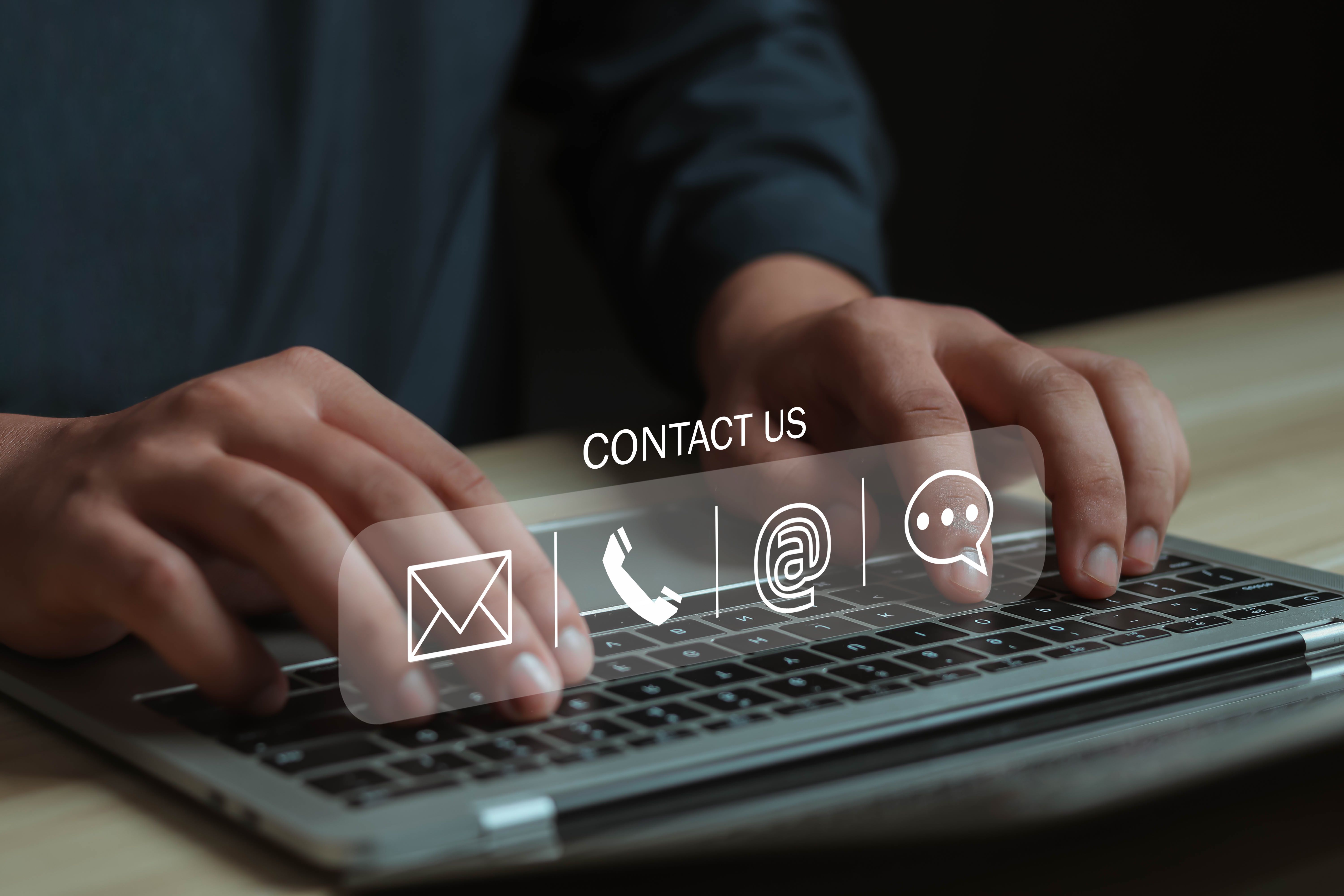 Businessman using virtual screen contact icon contact us or connect customer support hotline contact customer phone support online customer support concept copy space on computer screen