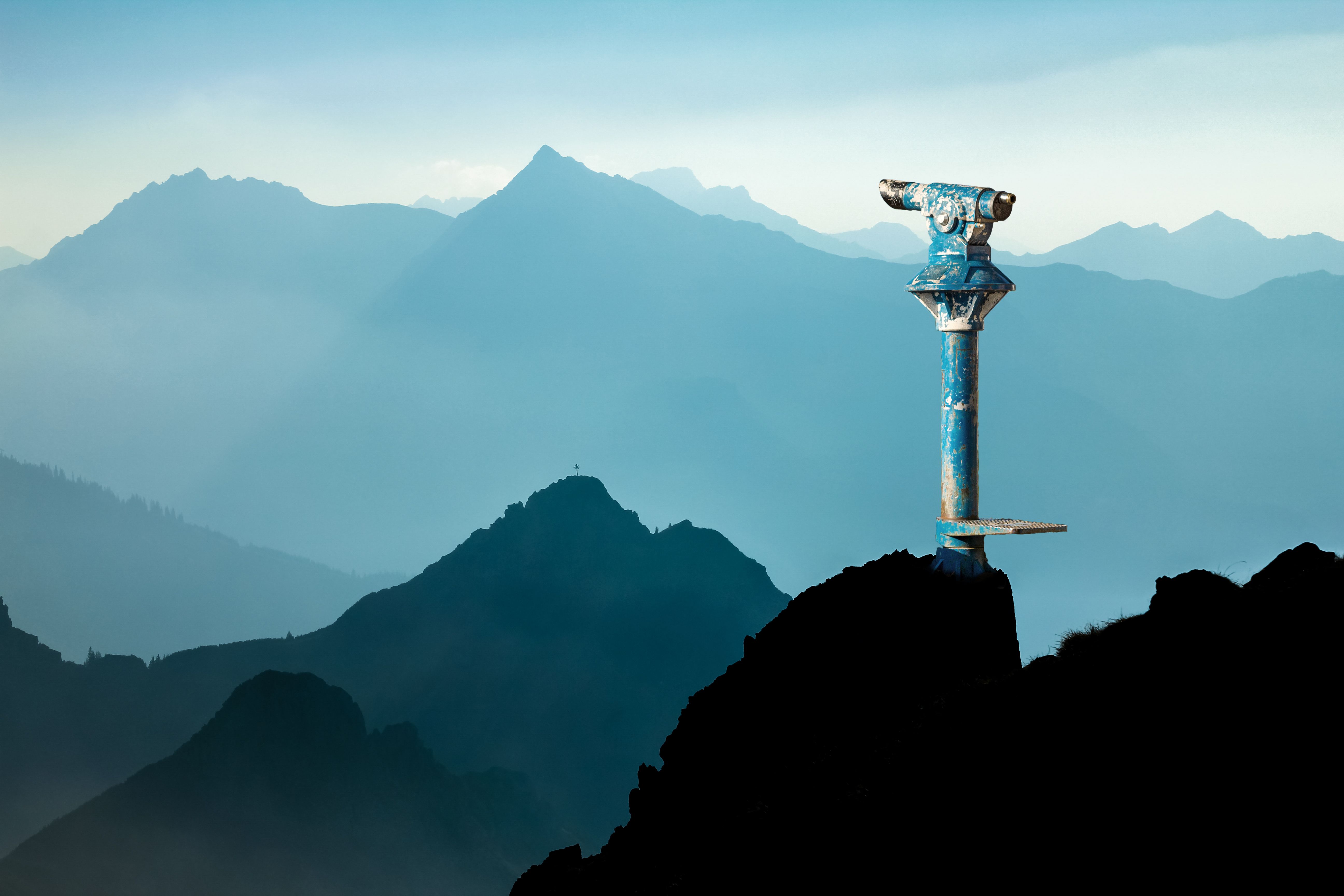 Public binoculars and Mountain Silhouettes at Sunrise. Concept for foresight and vision for new business solutions and creative ideas. Alps, Allgau, Bavaria, Germany.