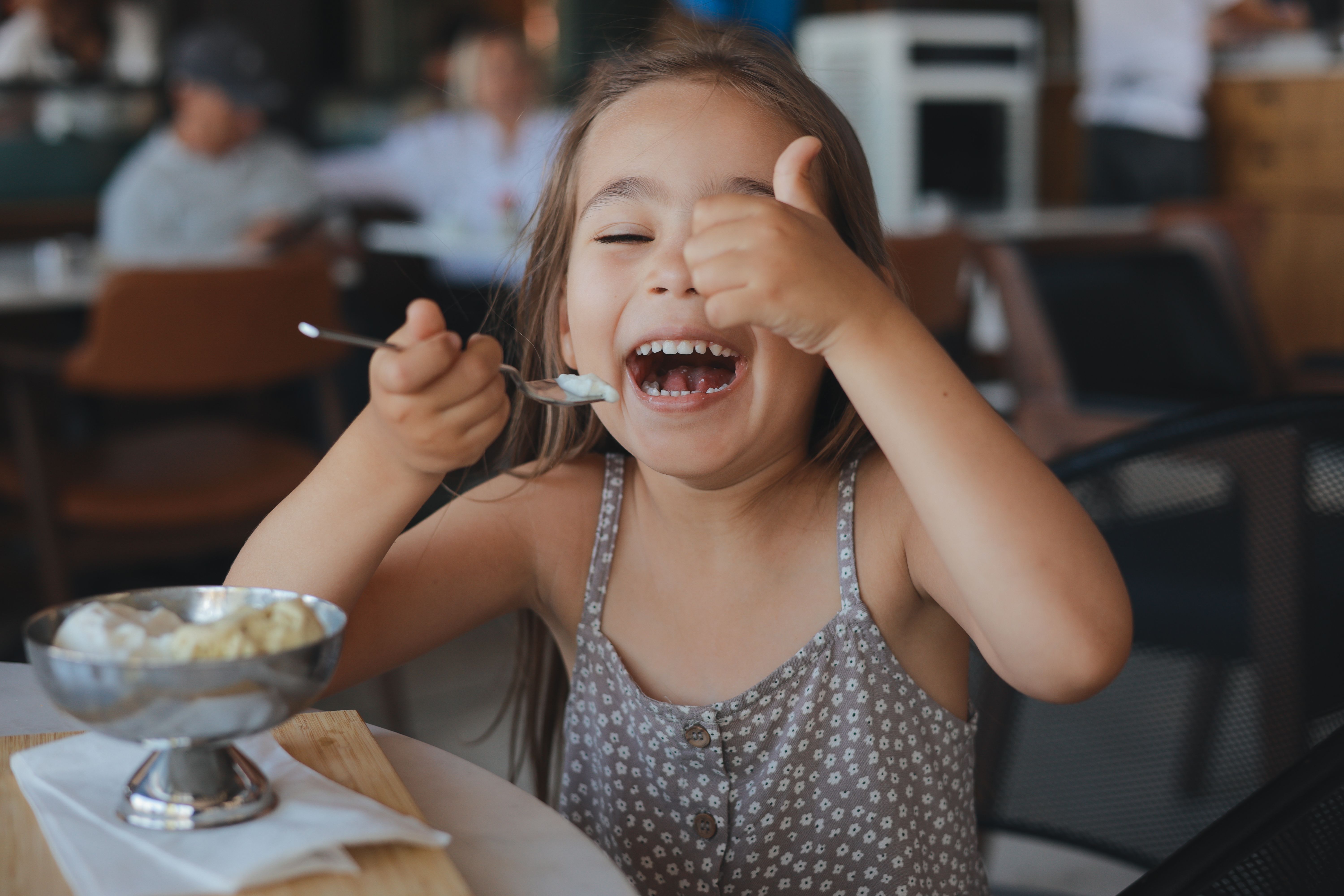 Little girl eating ice cream in cup