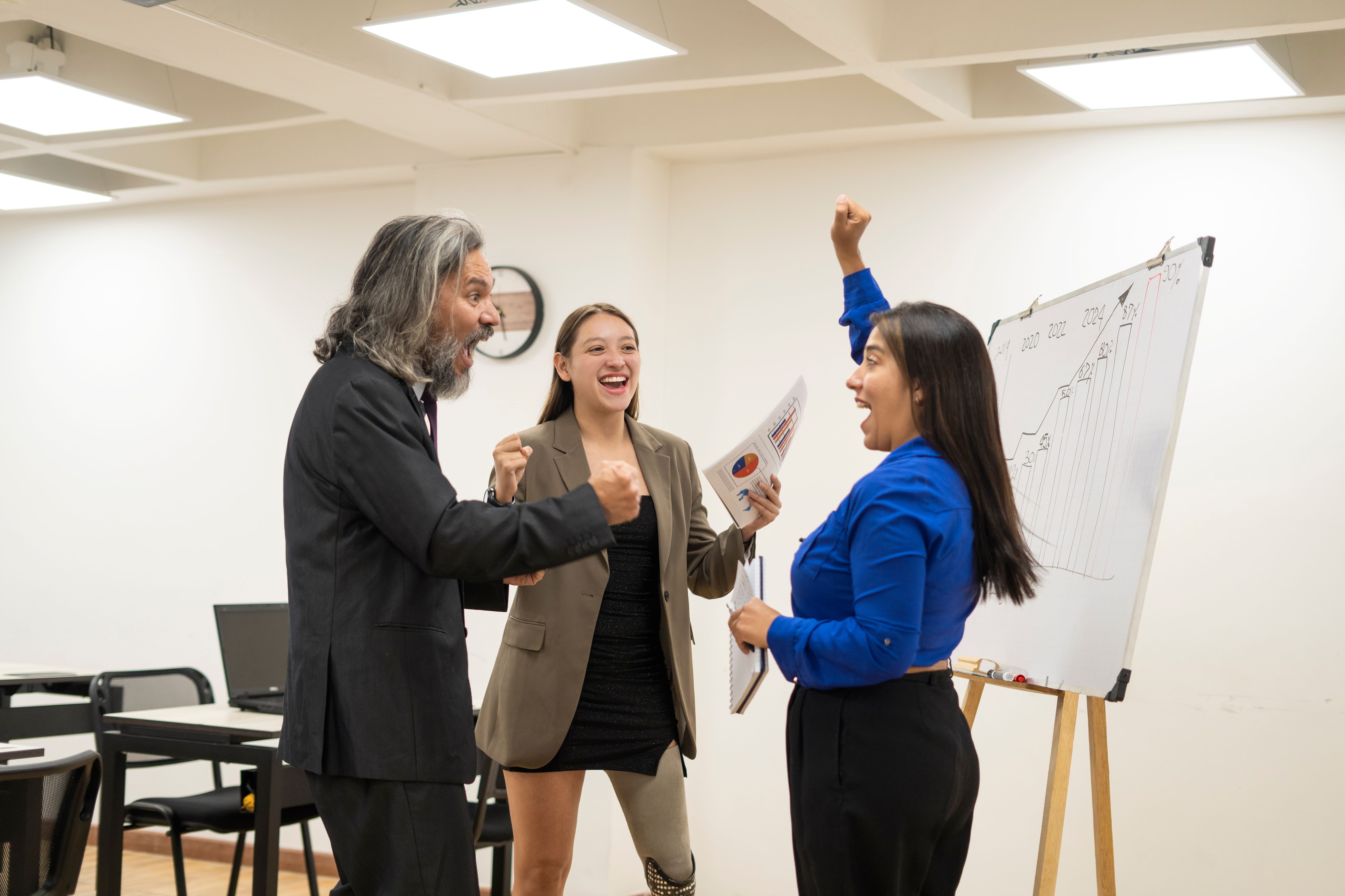 Group of colleagues celebrating success in the office.