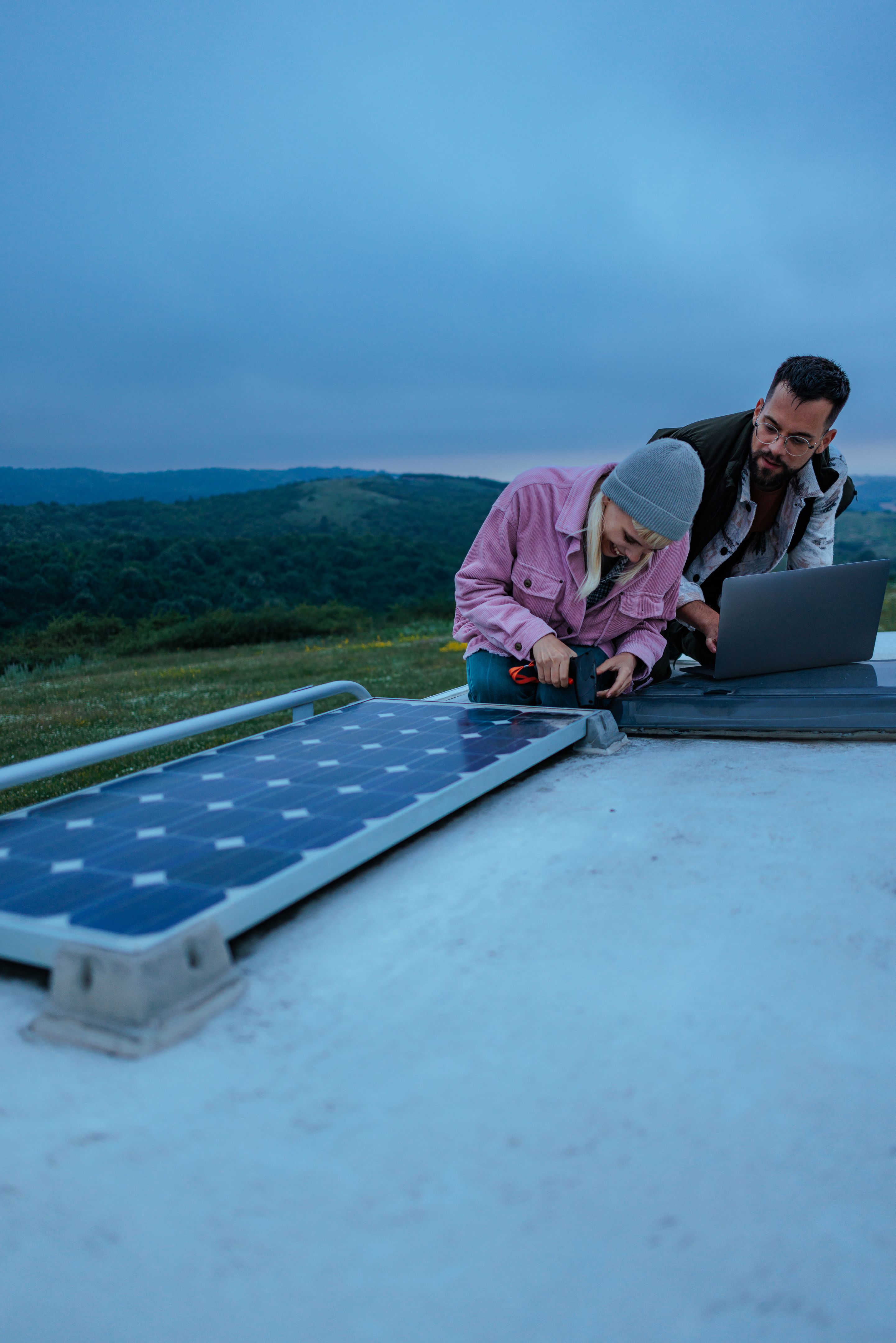 Technicians installing solar panel on camper van roof