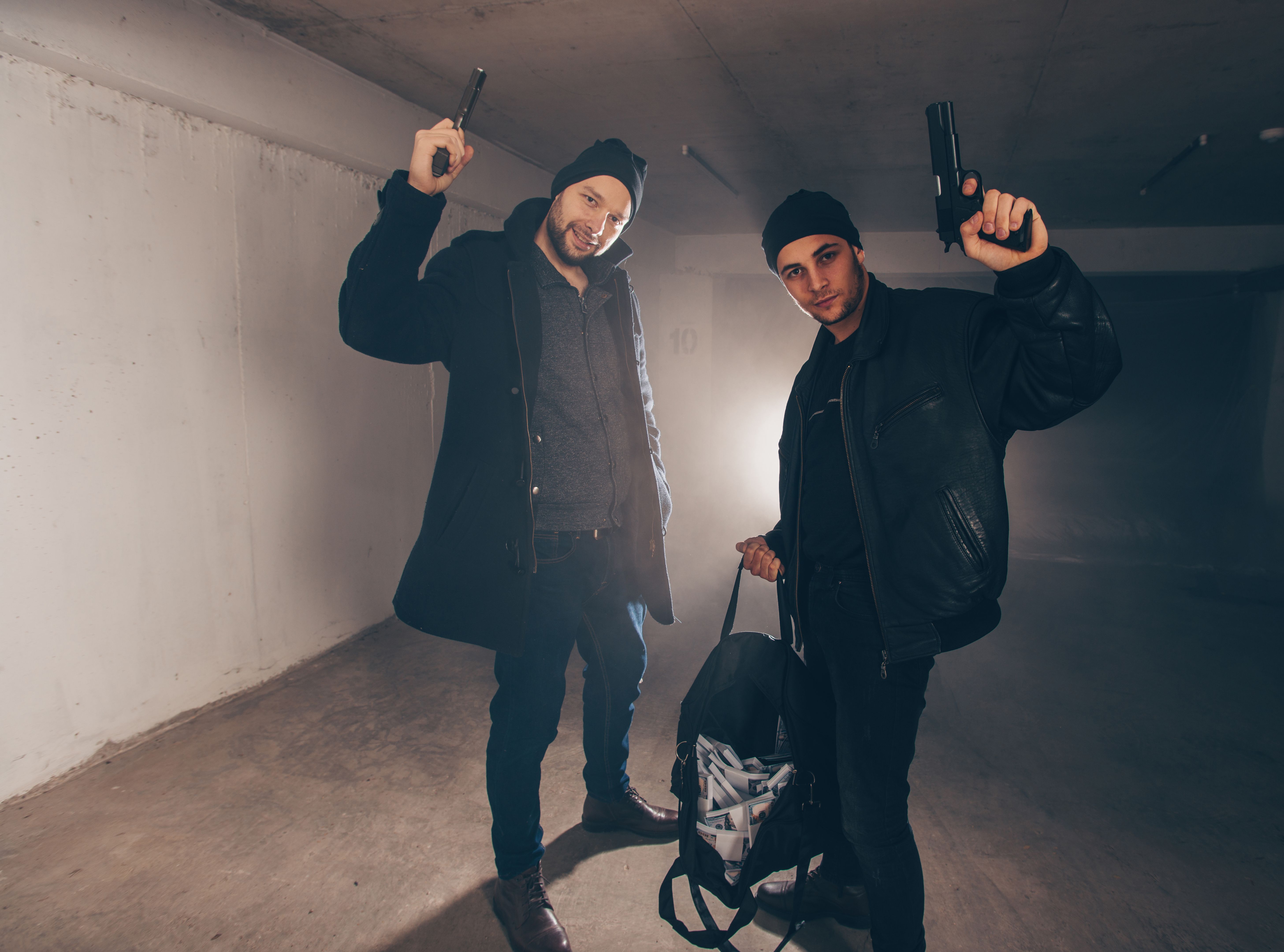 Burglars with stolen money standing in a garage