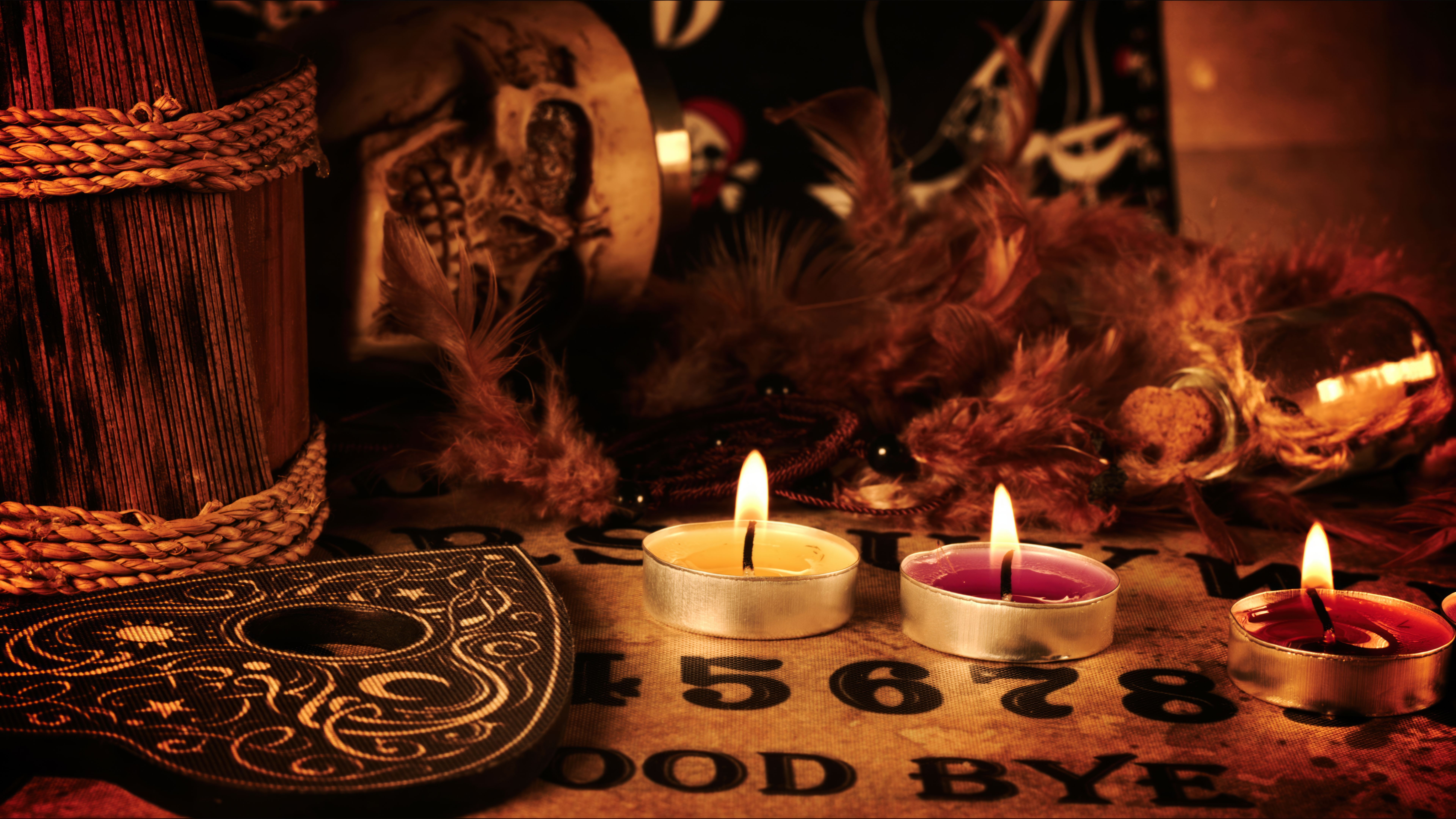 Creepy Skull on a Witchcraft Ouija Board and Candles Creepy Skull on a Witchcraft Ouija Board and Candles