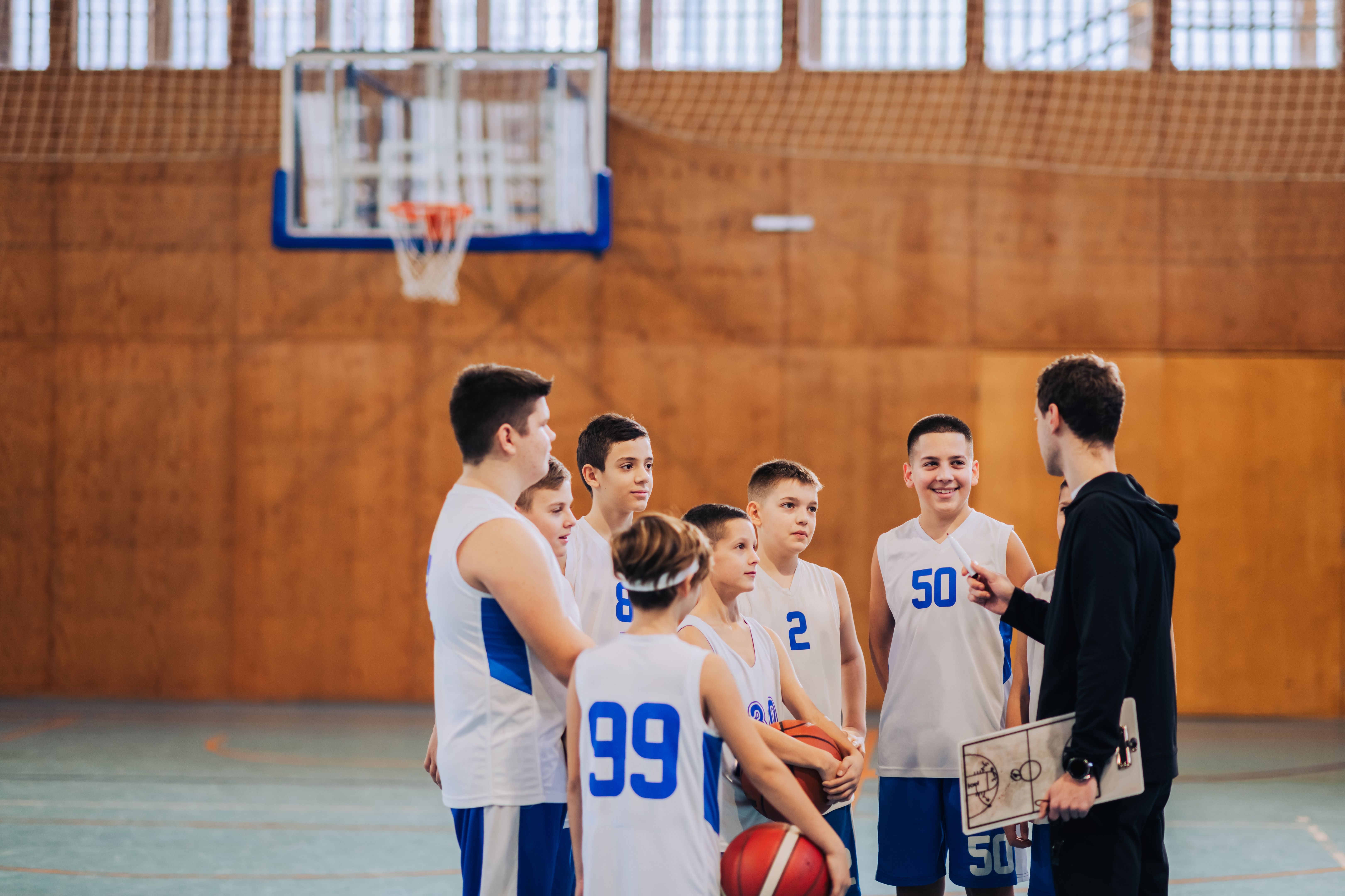 Basketball coach engaging with team during practice Basketball coach engaging with team during practice