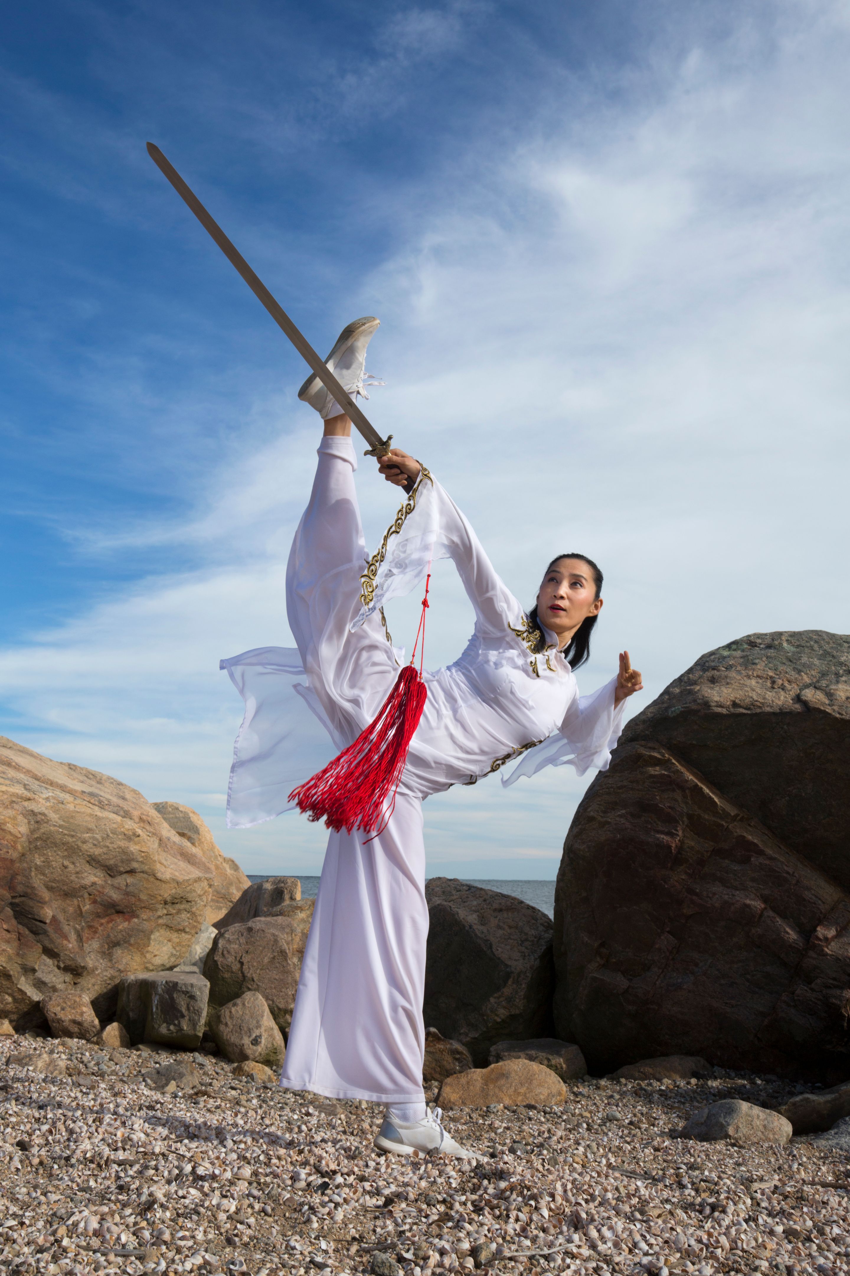 Young woman dancer with a sword on a Connecticut beach.