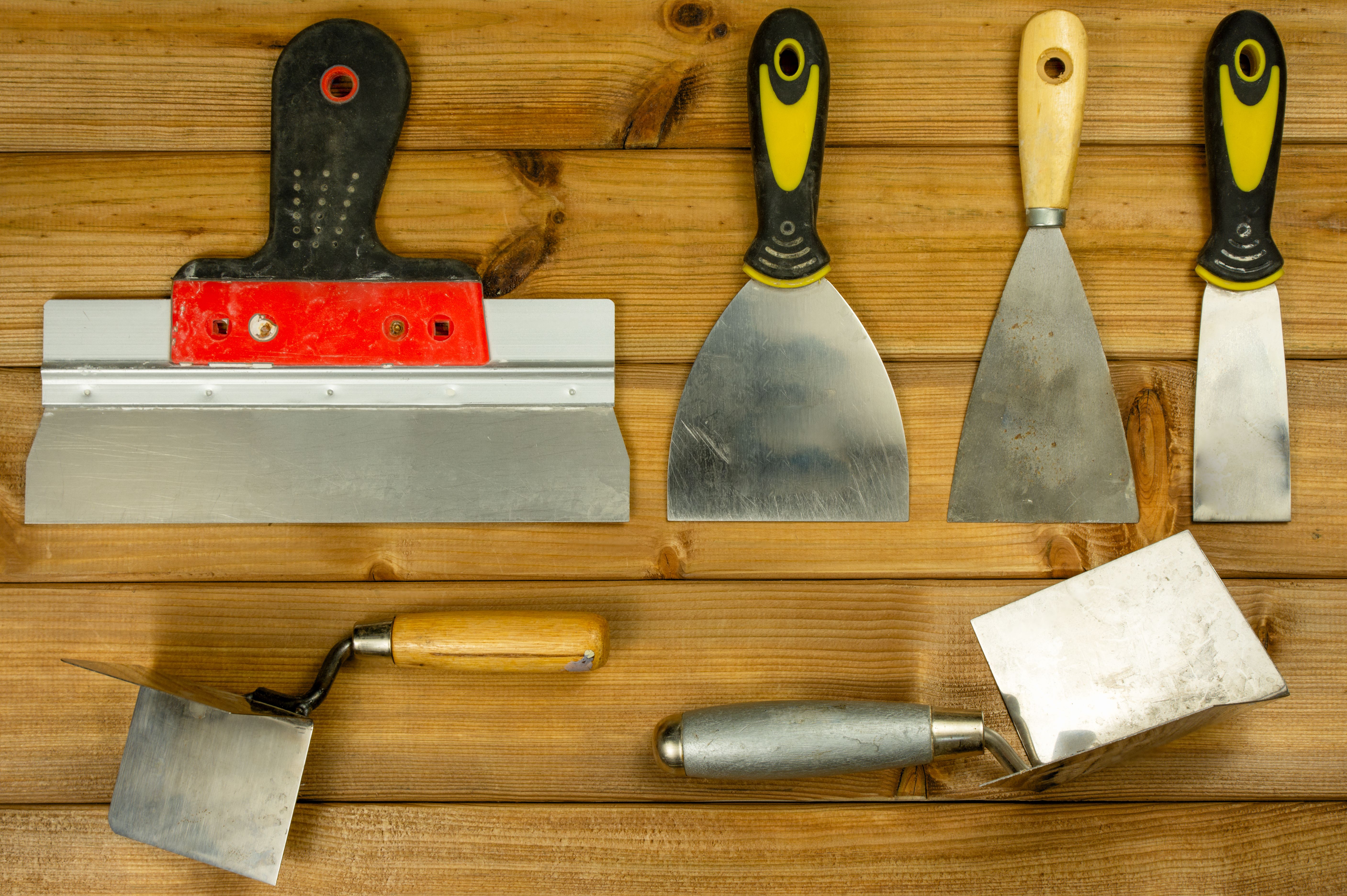 Set of house painter tools on wooden background, top view, flat lay.