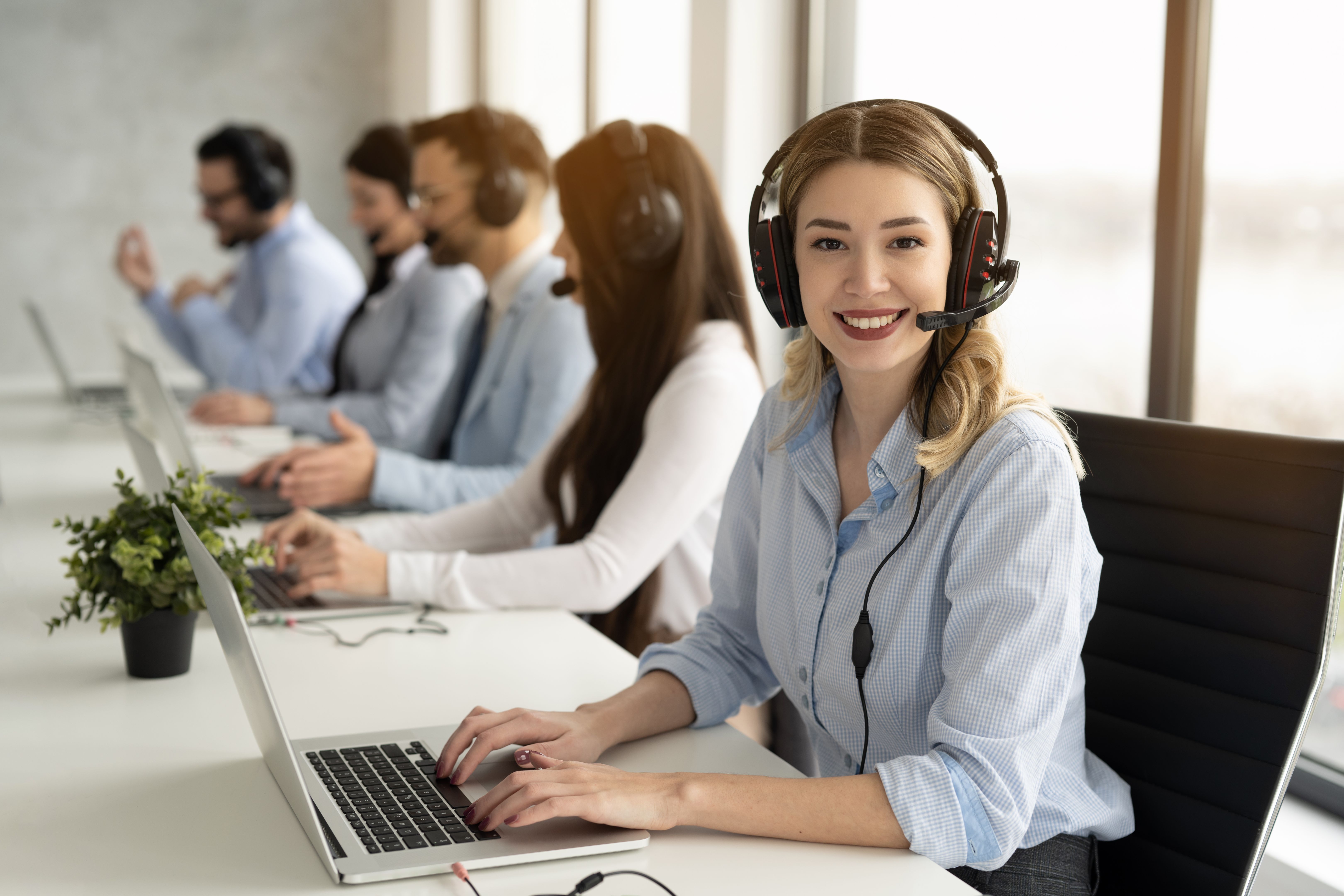 Operator woman with headset having conversation with client showing excellent communication skills at call center.