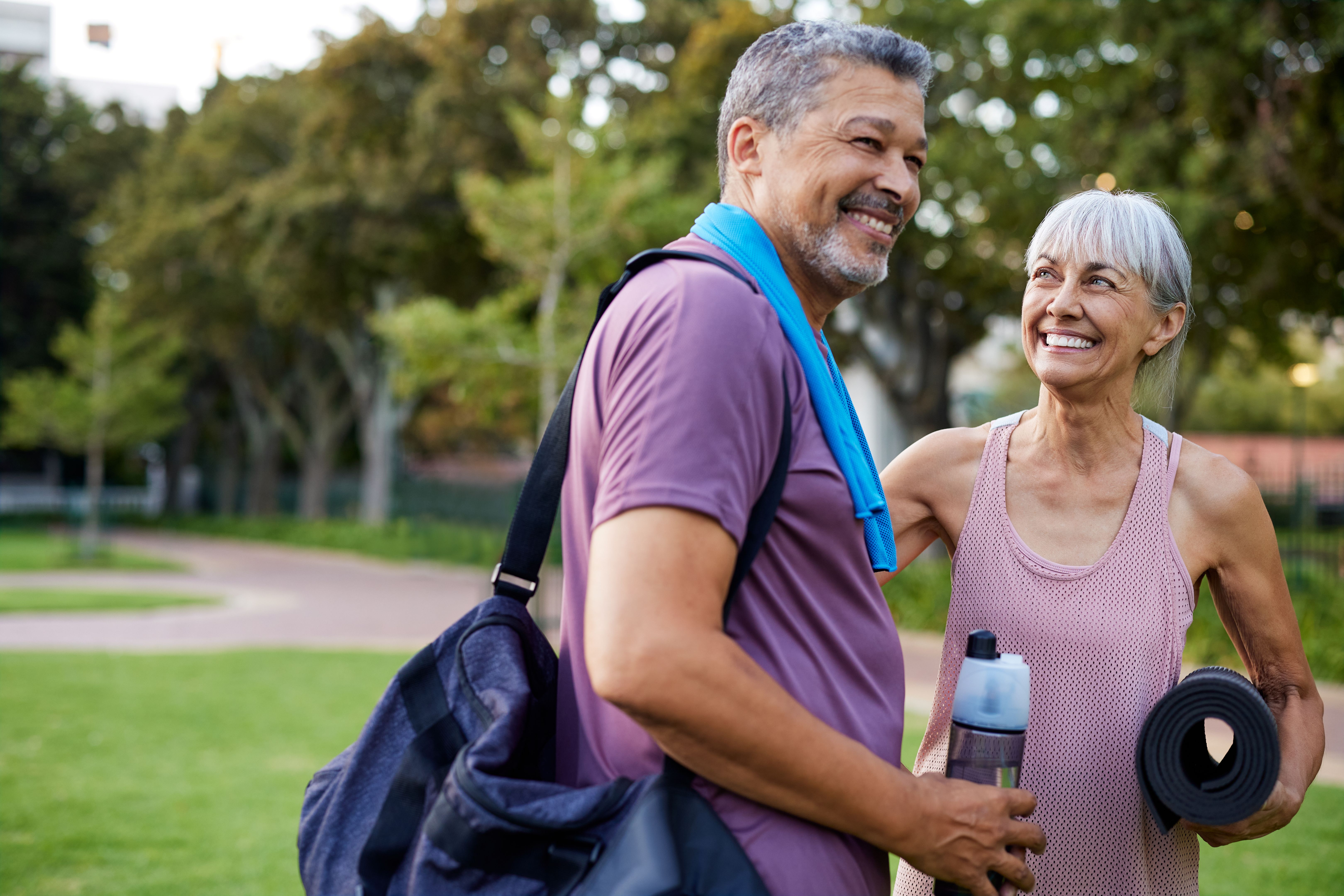 Happy senior multiethnic couple talking after fitness exercise