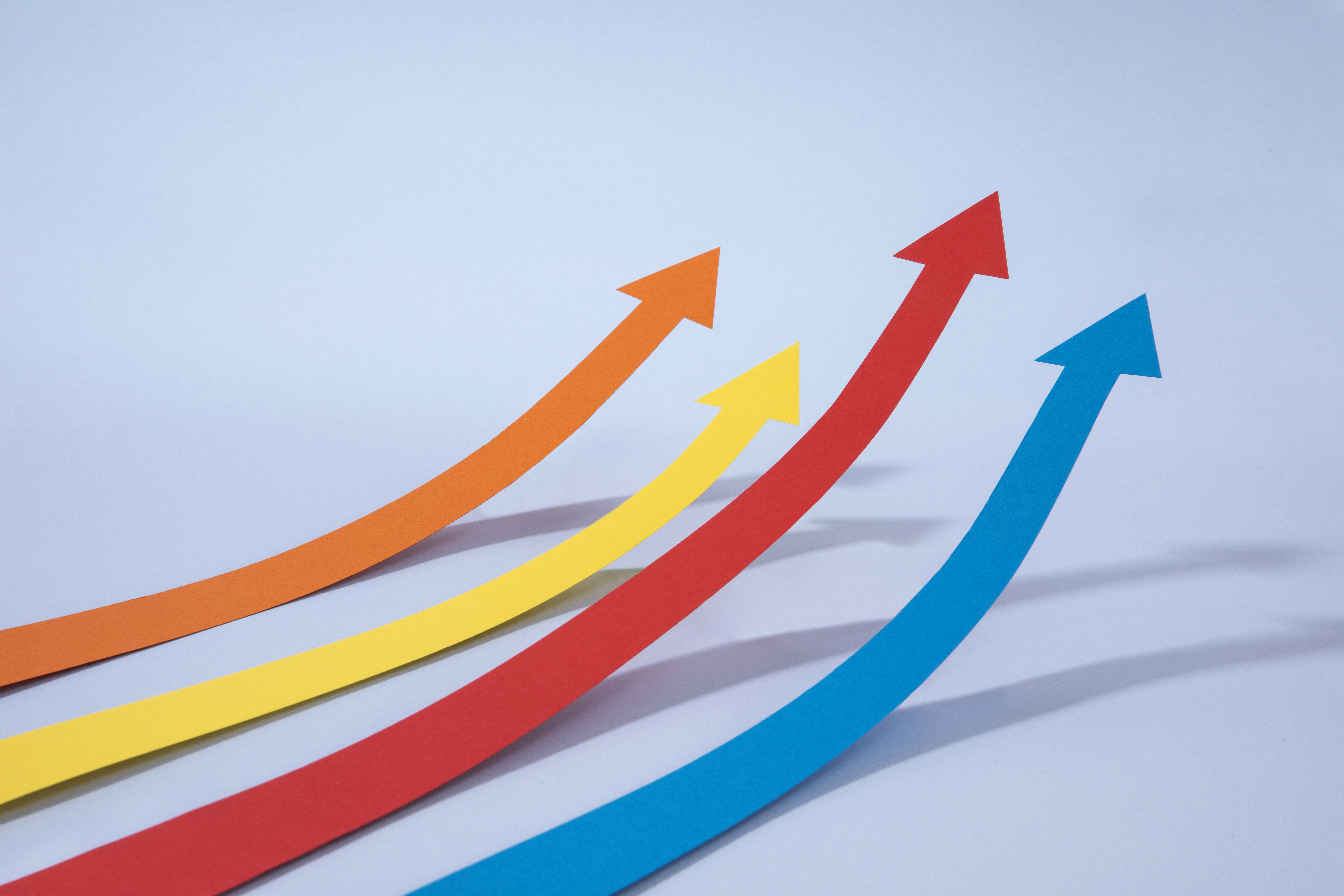 Four colorful upward-pointing arrows representing growth, progress, and continuous improvement in fostering a culture of excellence.
