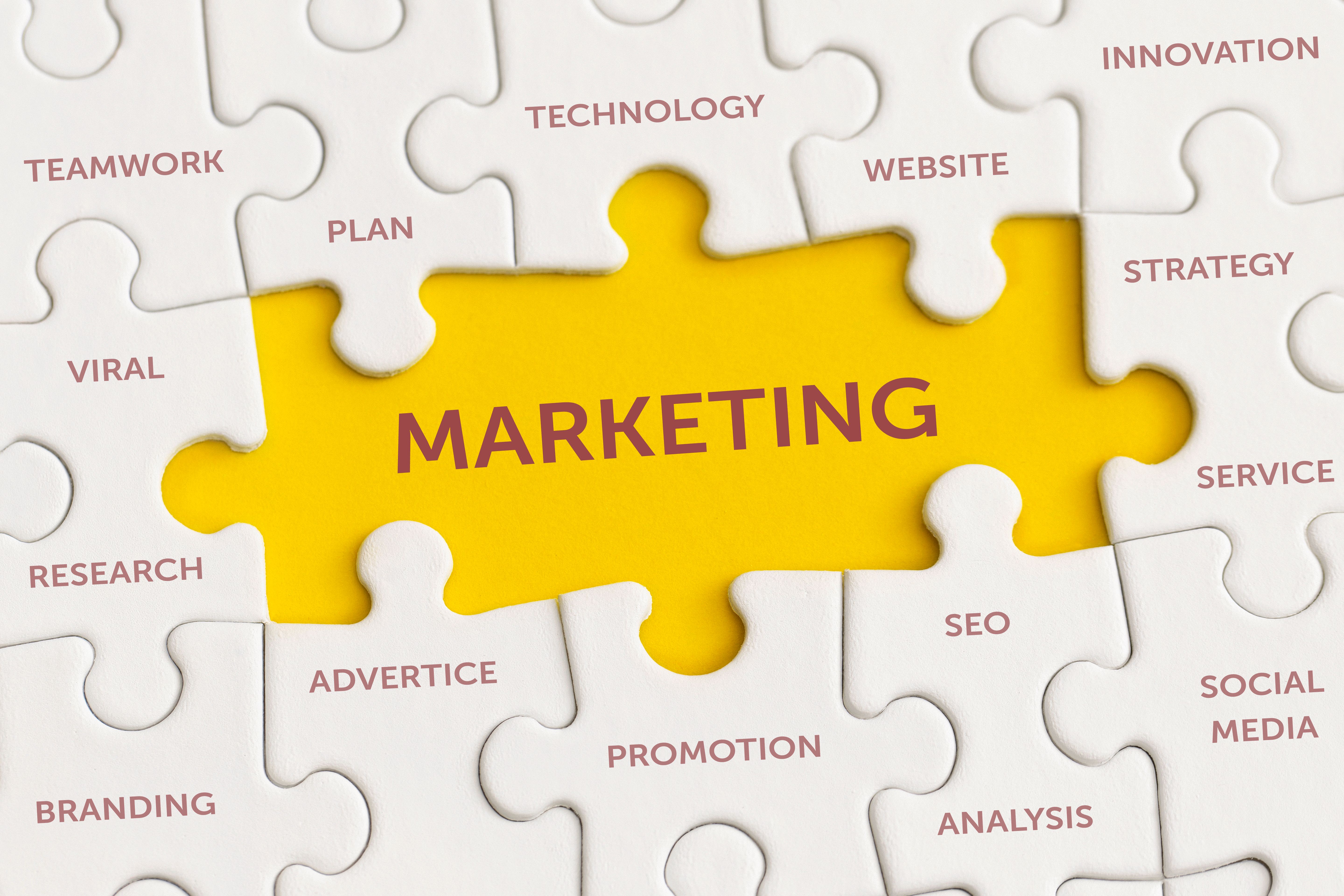 White details of puzzle with the text "Marketing" on yellow background.
