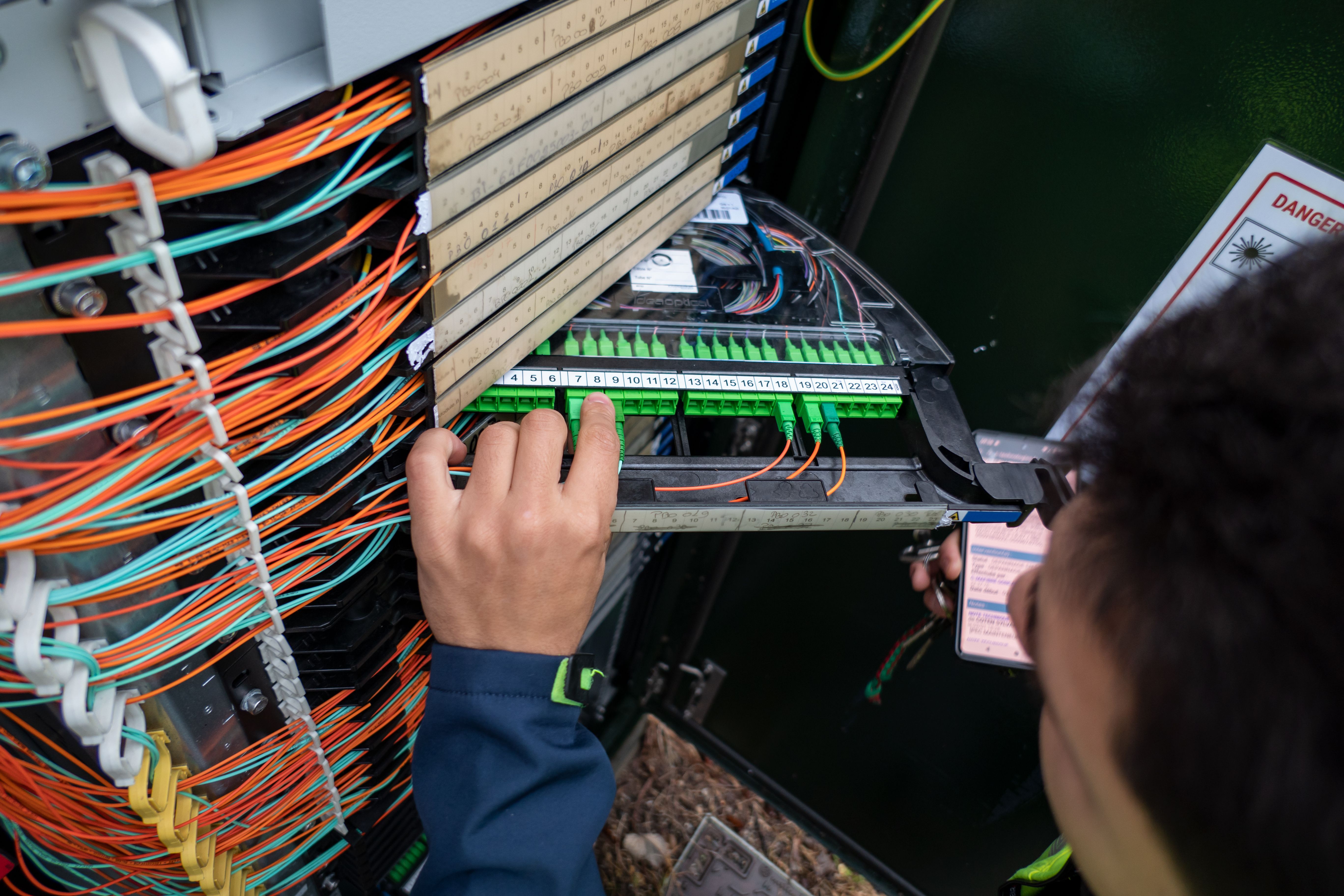 Fiber optic technician performs repair on cabinet