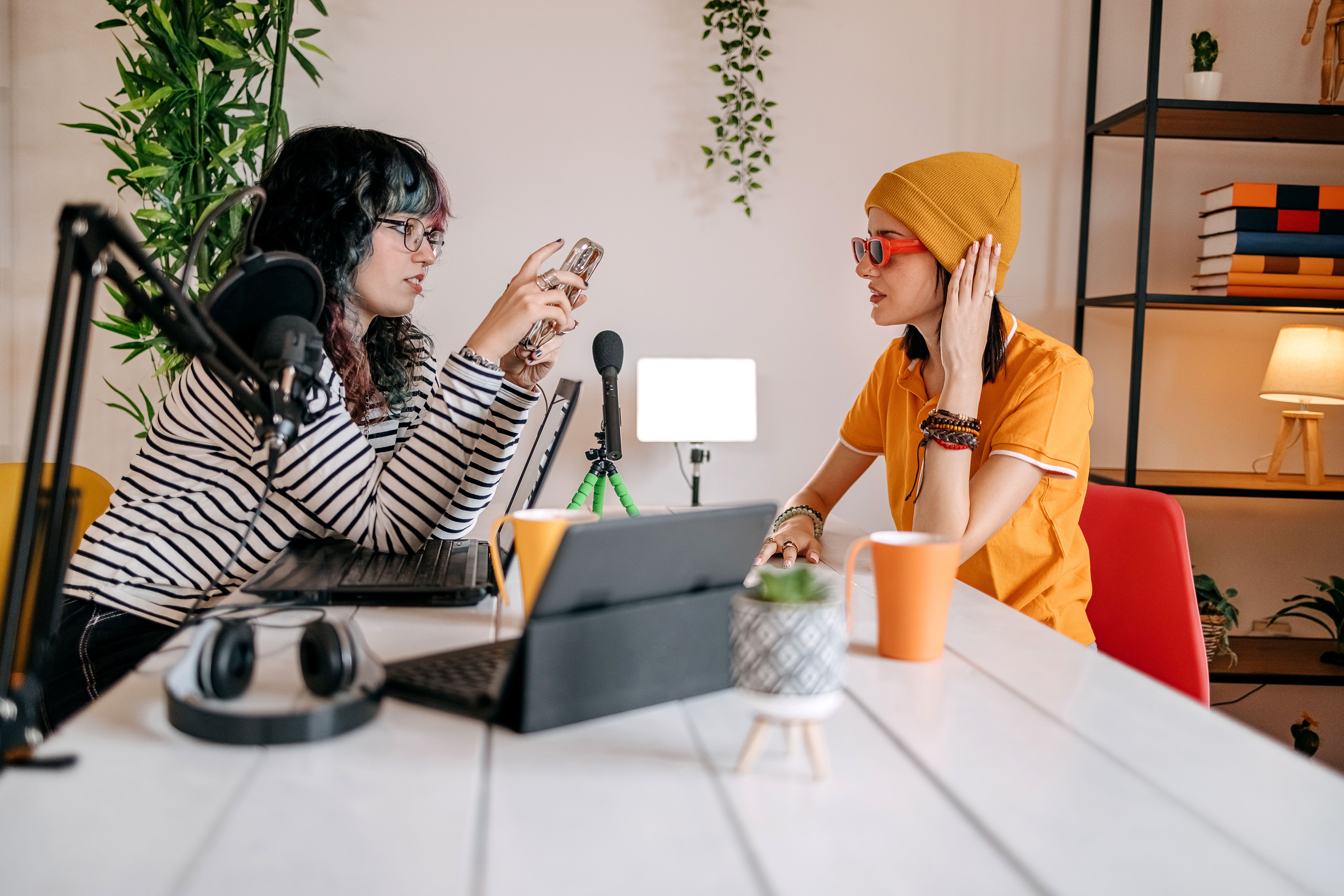 Female friends filming podcast at home while one is asking and other is answering questions
