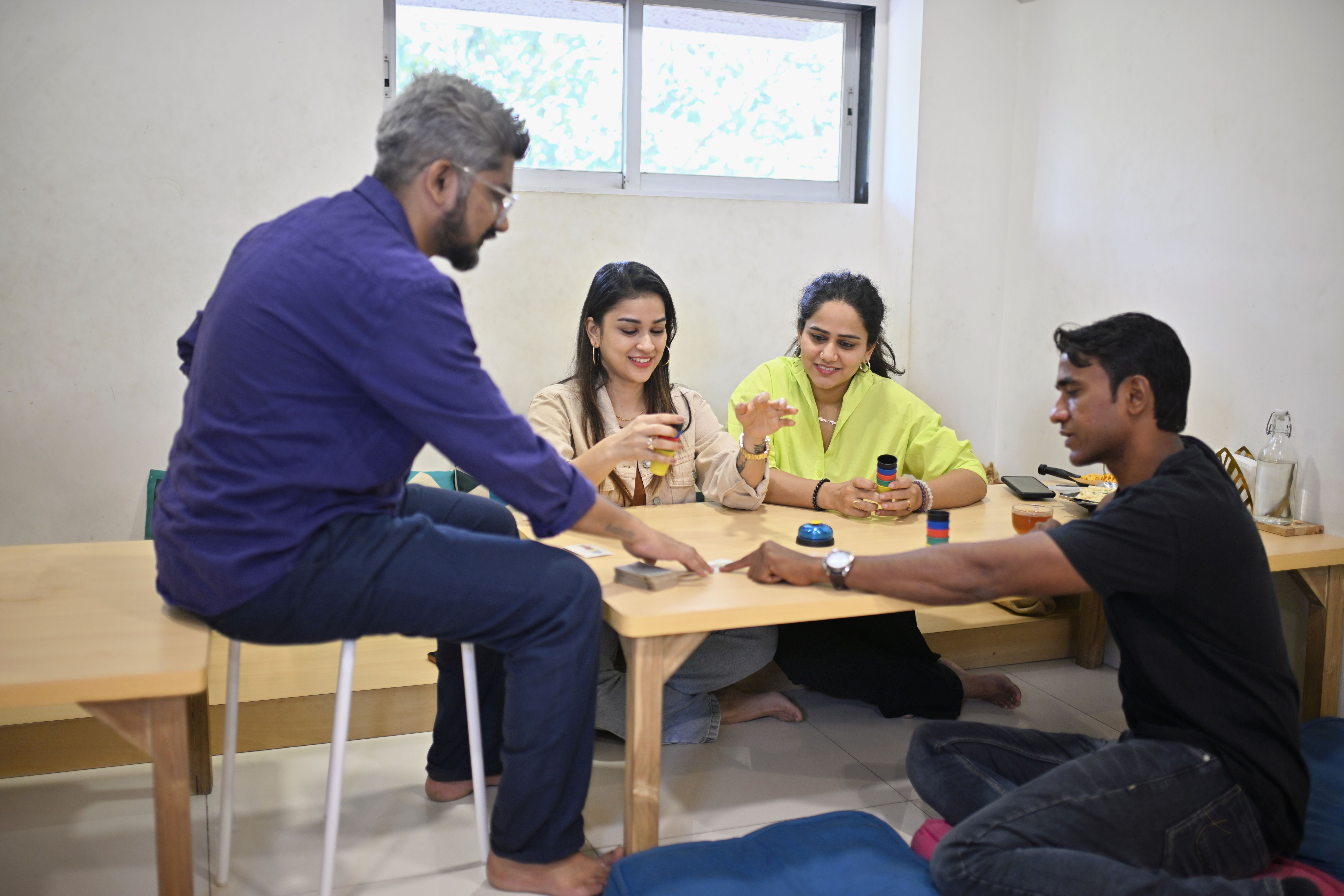 Group of friends playing a colourful cup game in a cafe