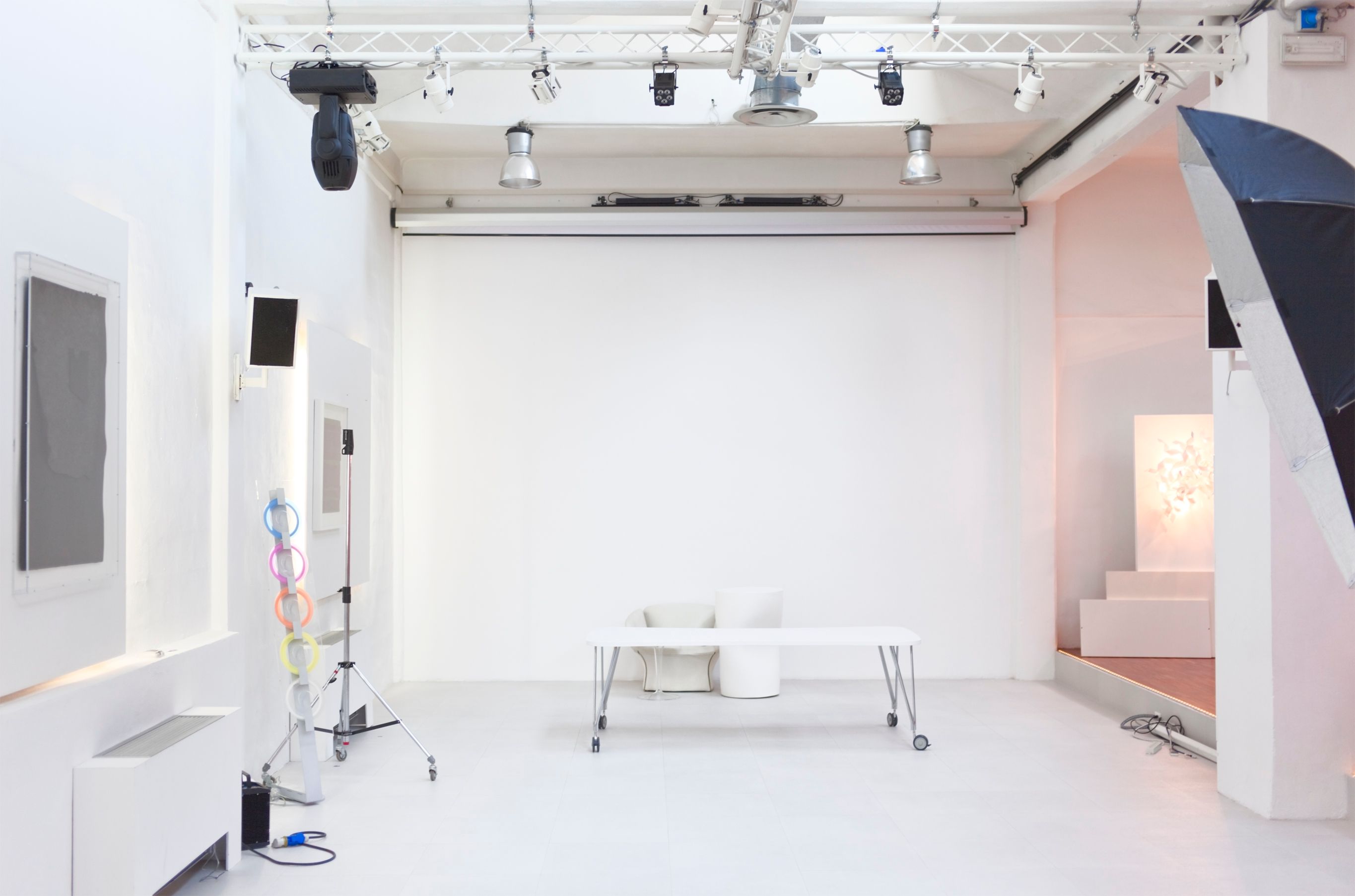 Empty white photographic studio with photo equipment.
