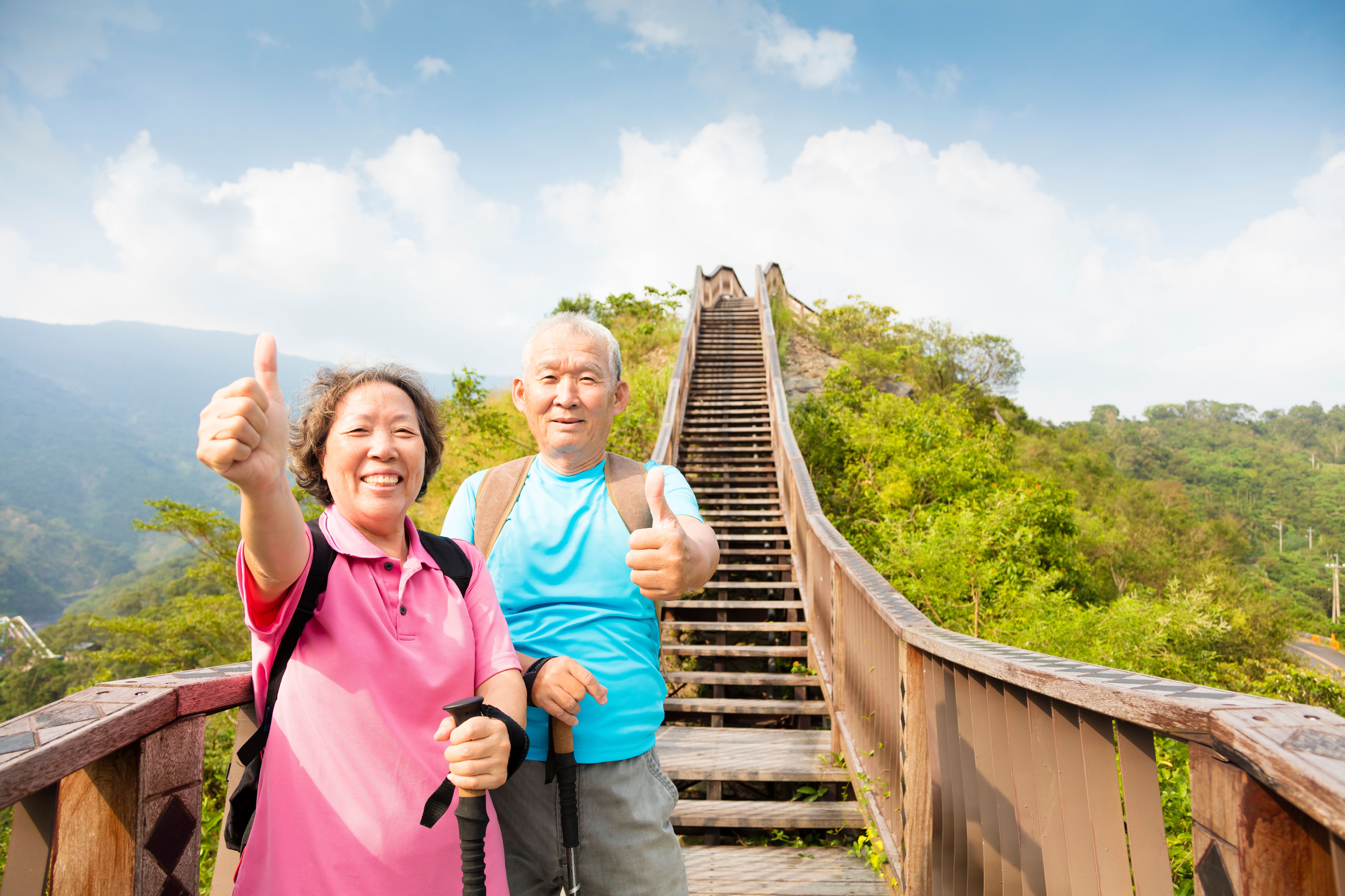 happy senior couple hiking on the mountain with thumbs up happy senior couple hiking on the mountain with thumbs up