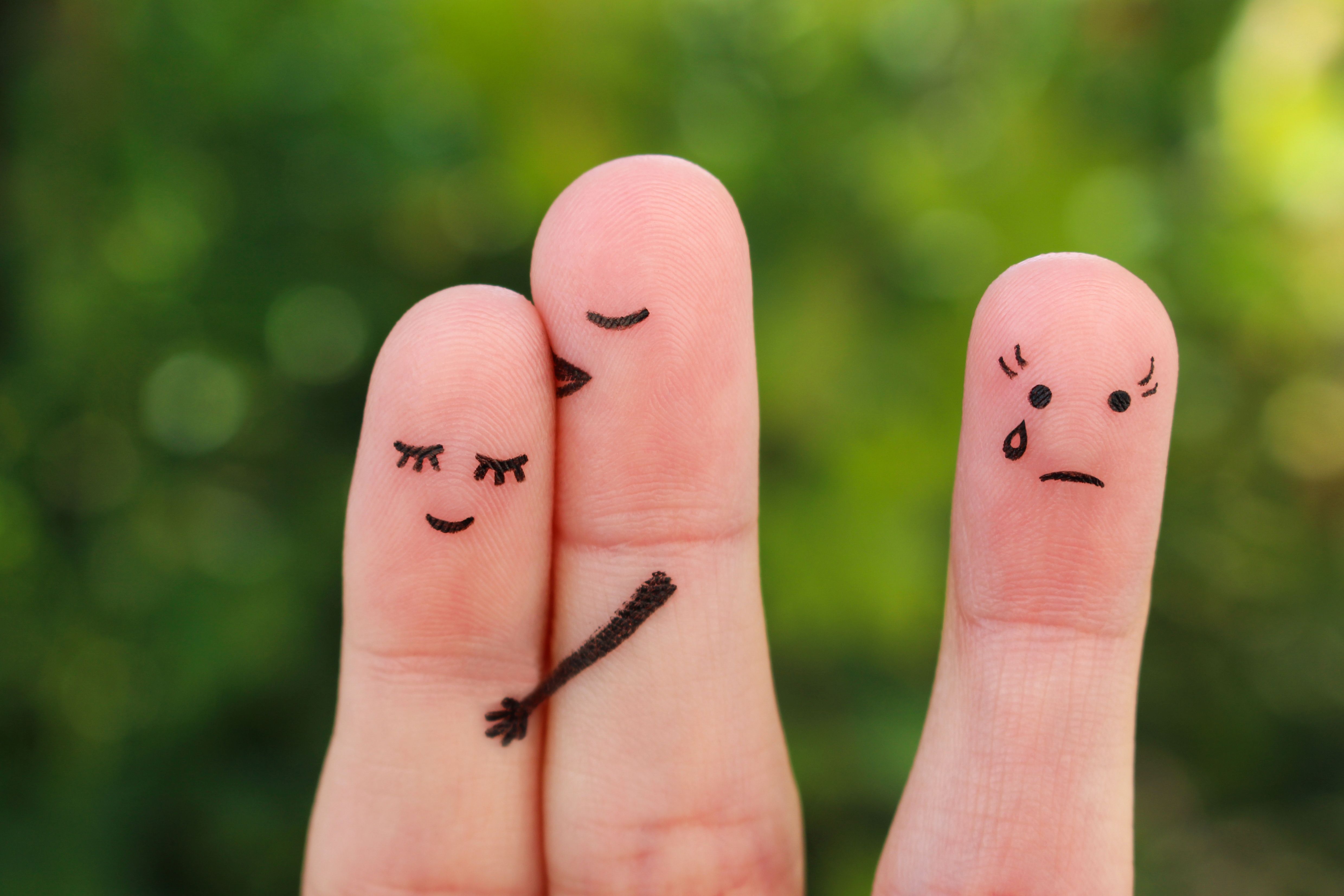 Fingers art of happy couple. Man kisses woman on cheek. Girl is jealous and angry.