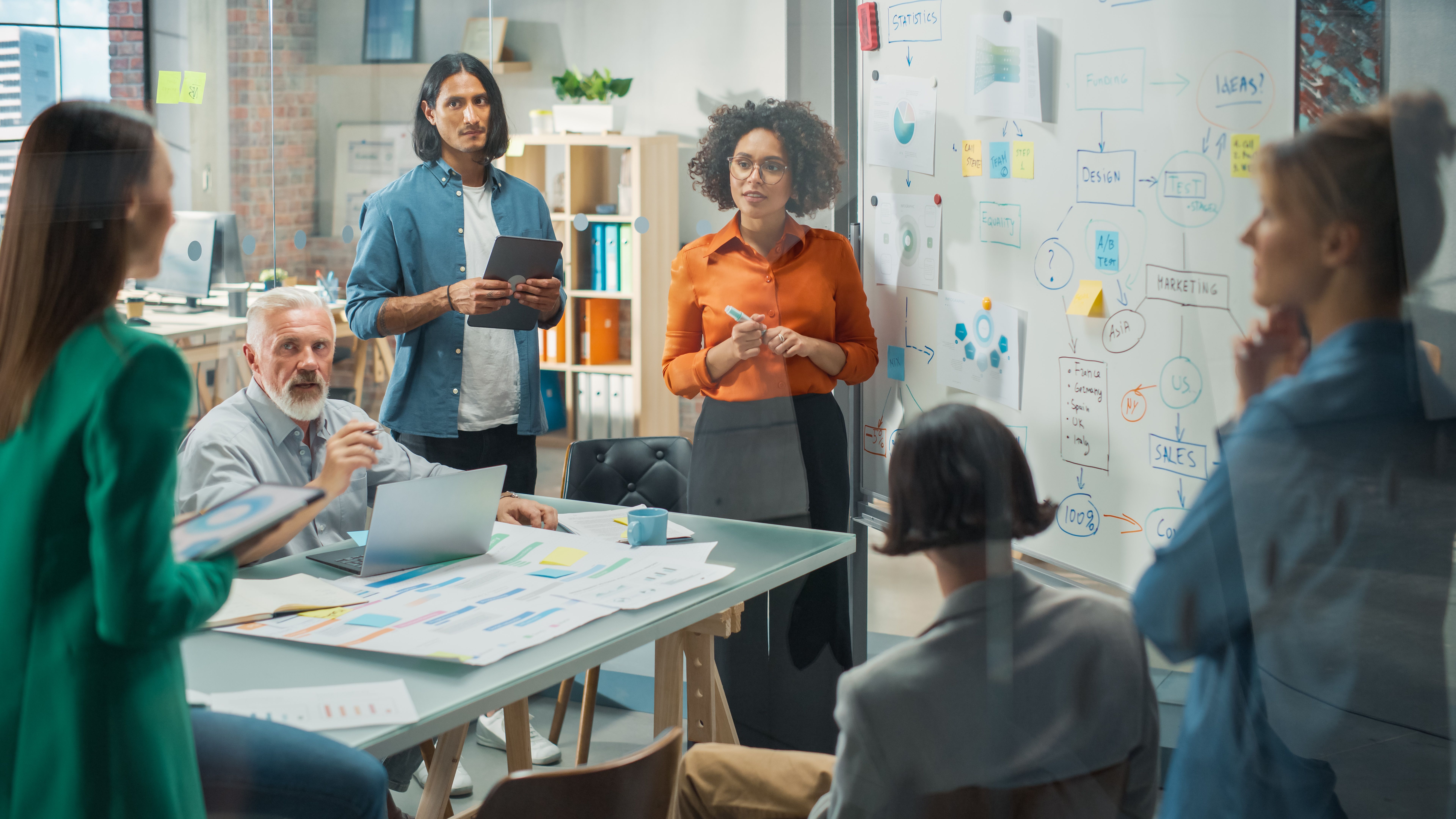 Diverse Modern Office: Successful Black Female Digital Entrepreneur Uses Whiteboard with Big Data, Statistics, Talks about Company Growth, Discusses Strategy with Investors, Top Managers, Executives