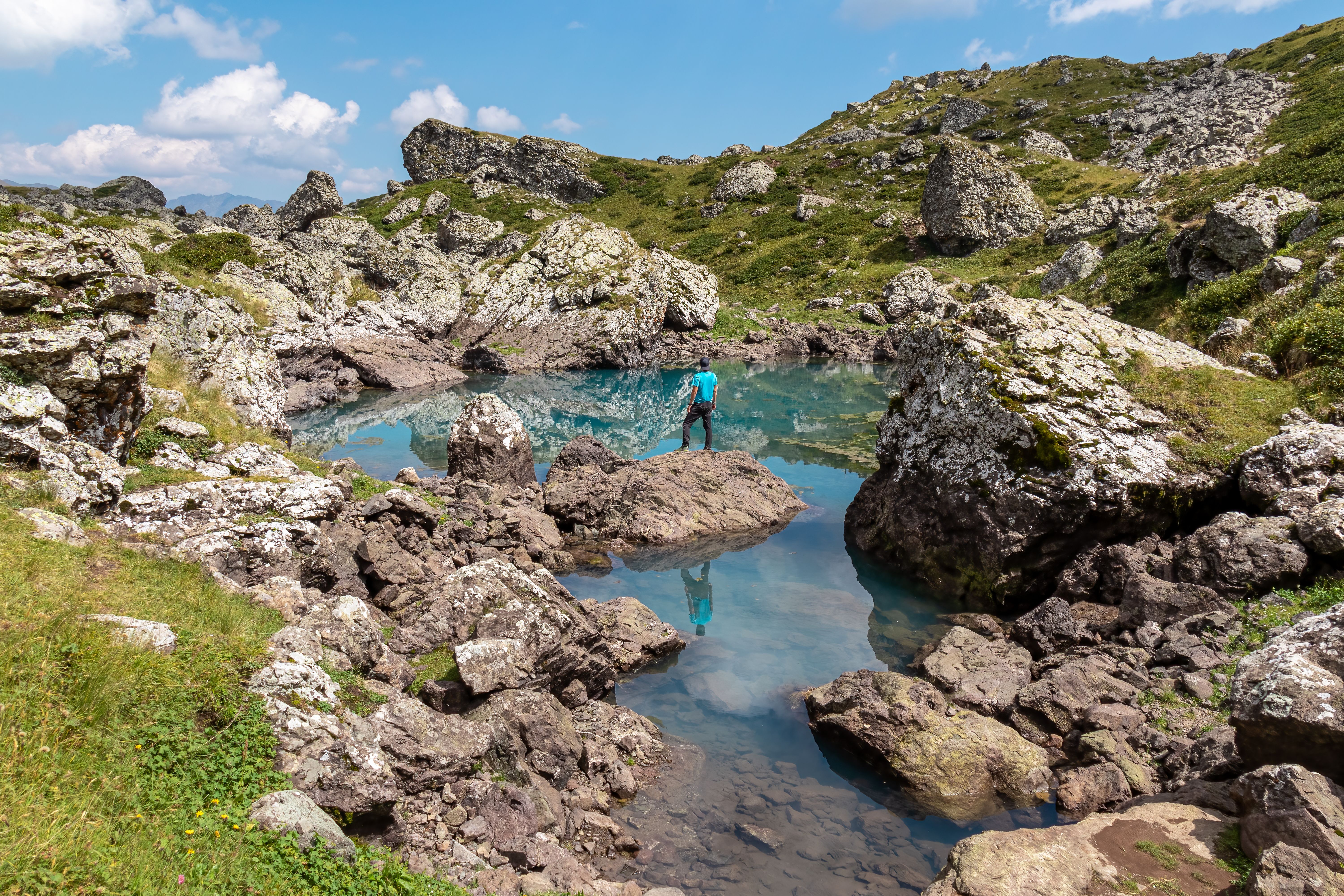 Roshka - A male hiker and the colorful Abudelauri mountain lakes in the Greater Caucasus Mountain Range.