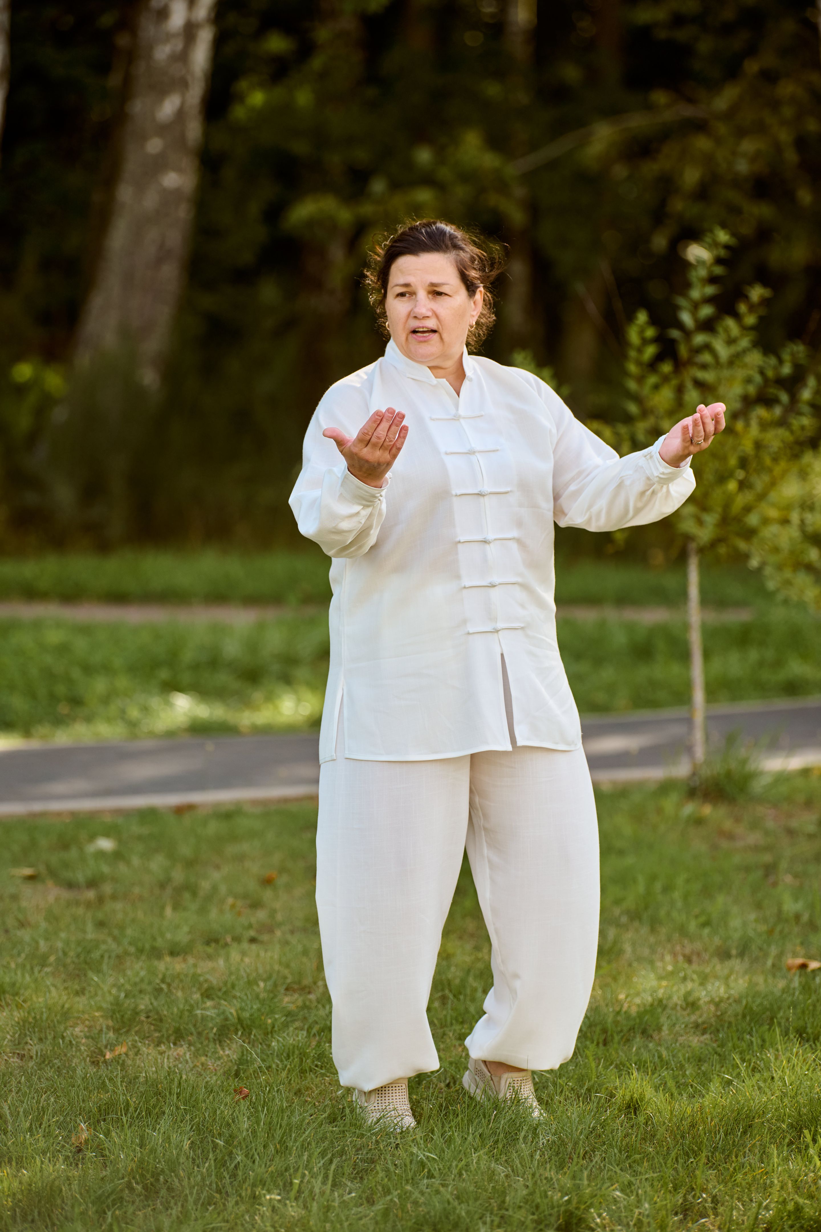 Mature caucasian woman practicing qigong in park on sunny day