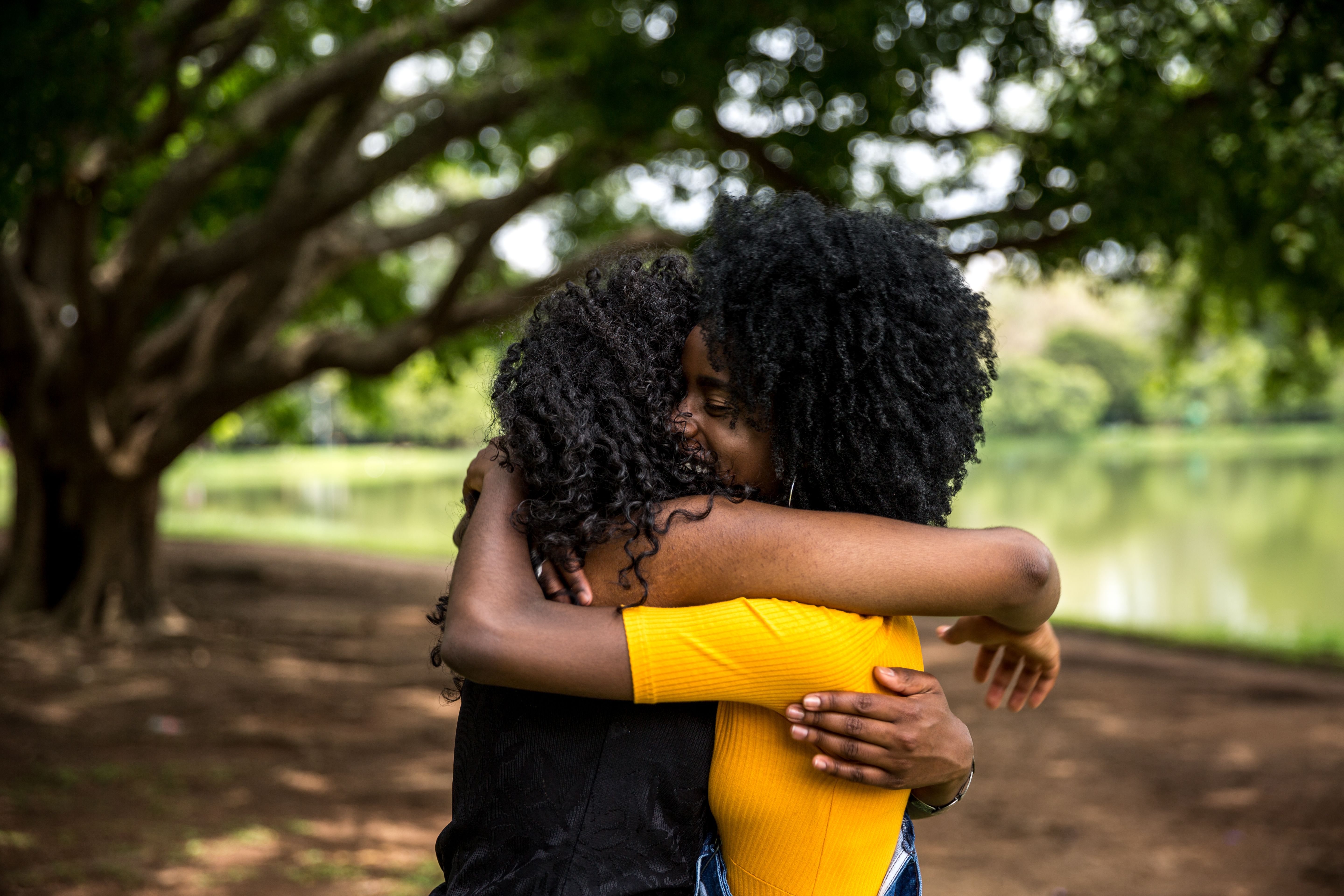 Afro friends hugging in the park