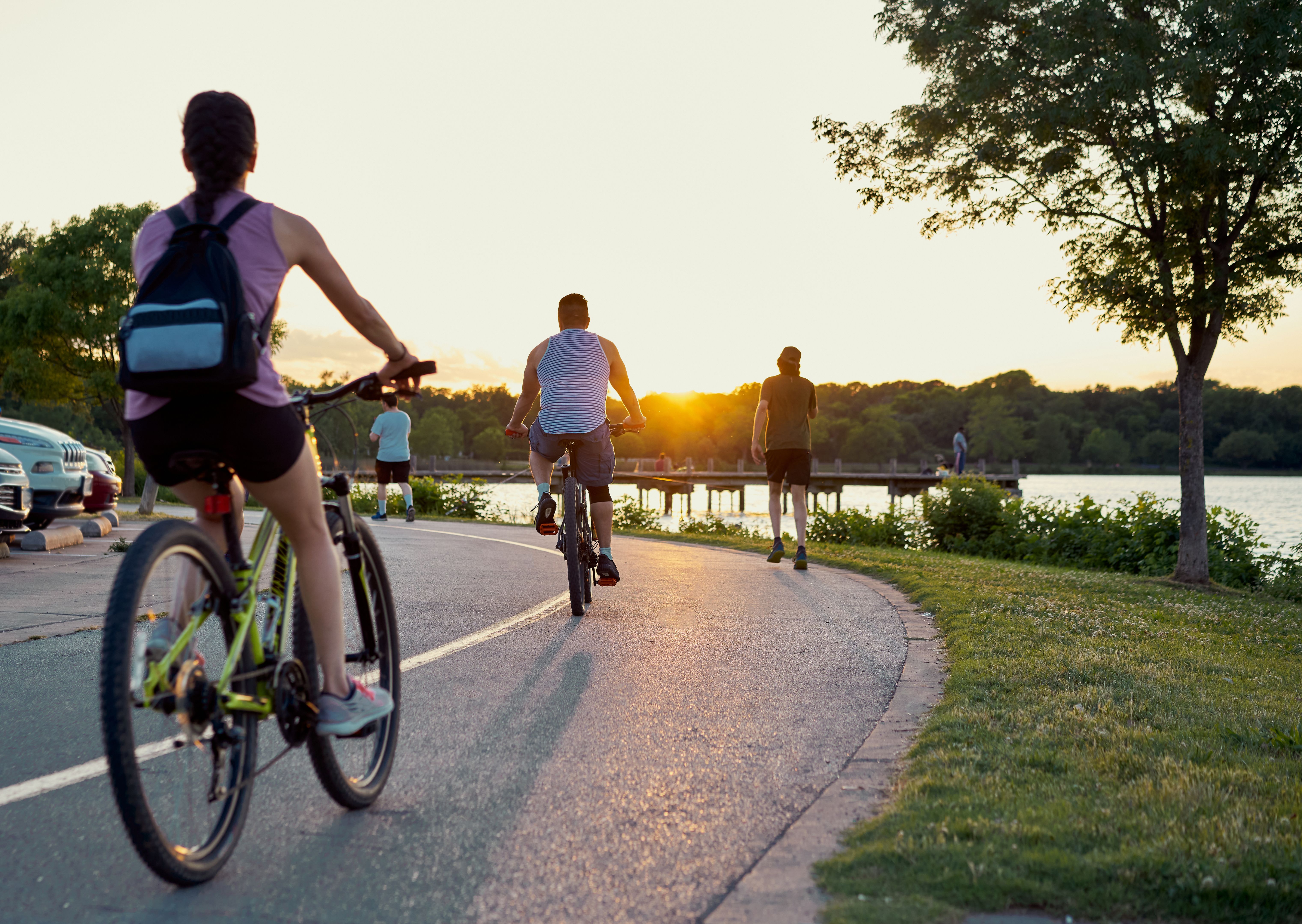 People from the back doing outdoor sports after coronavirus quarantine near a lake.